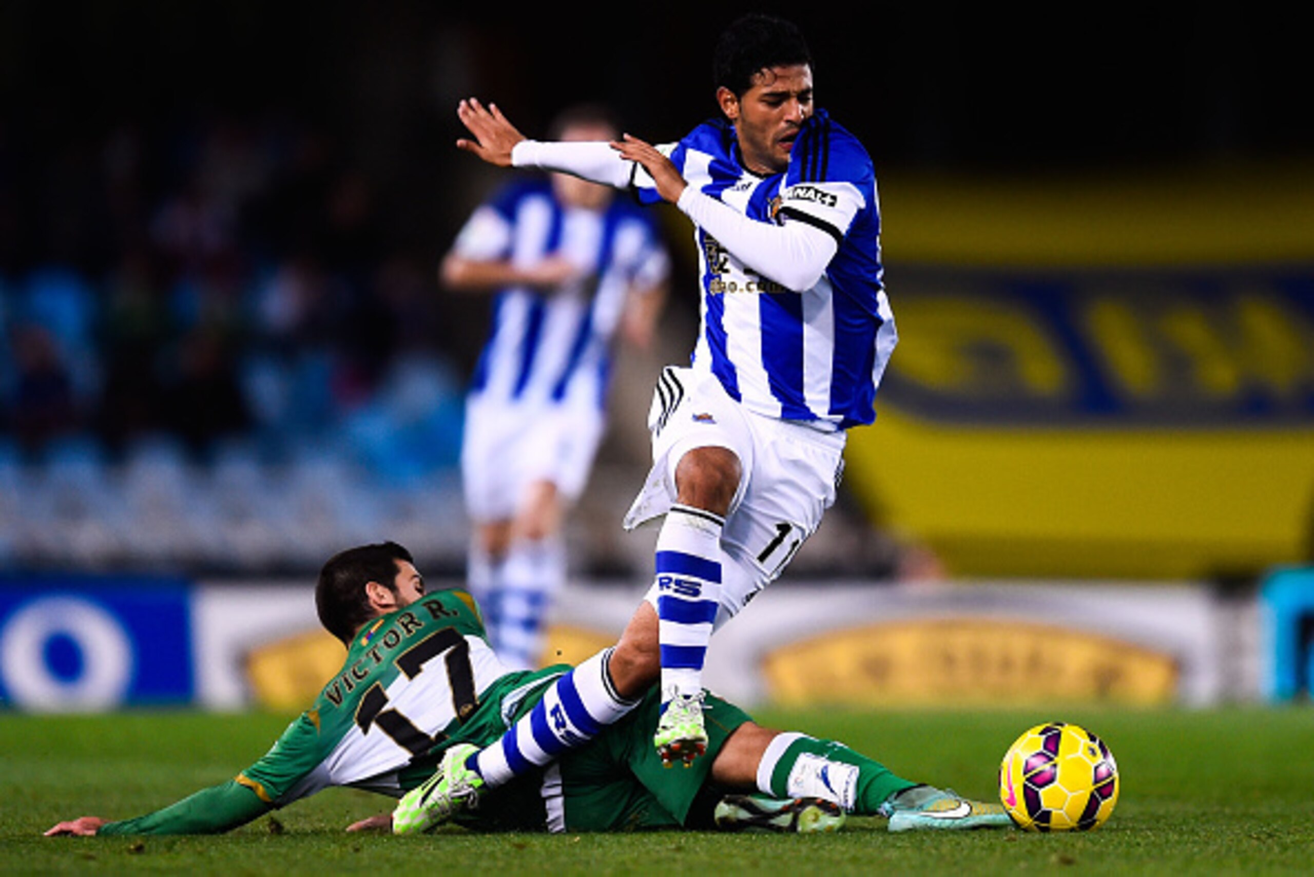 SAN SEBASTIAN, SPAIN - NOVEMBER 28:  Carlos Vela Garrido of Real Sociedad competes for the ball with Victor Rodriguez of Elche FC during the La Liga match between Real Socided and Elche FC at Estadio Anoeta on November 28, 2014 in San Sebastian, Spain.  (