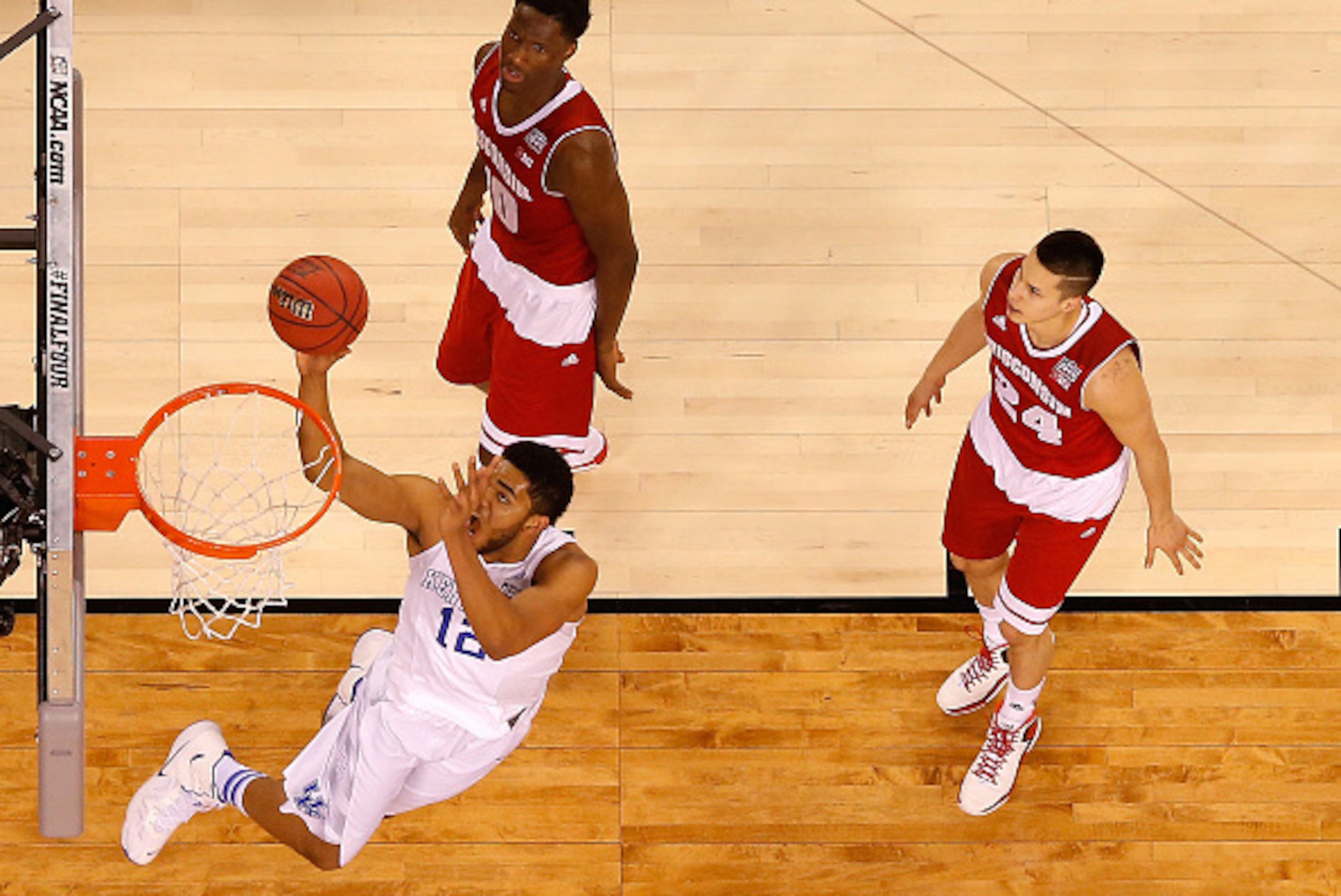 INDIANAPOLIS, IN - APRIL 04: Karl-Anthony Towns #12 of the Kentucky Wildcats drives to the basket in the second half against Nigel Hayes #10 and Bronson Koenig #24 of the Wisconsin Badgers during the NCAA Men's Final Four Semifinal at Lucas Oil Stadium on