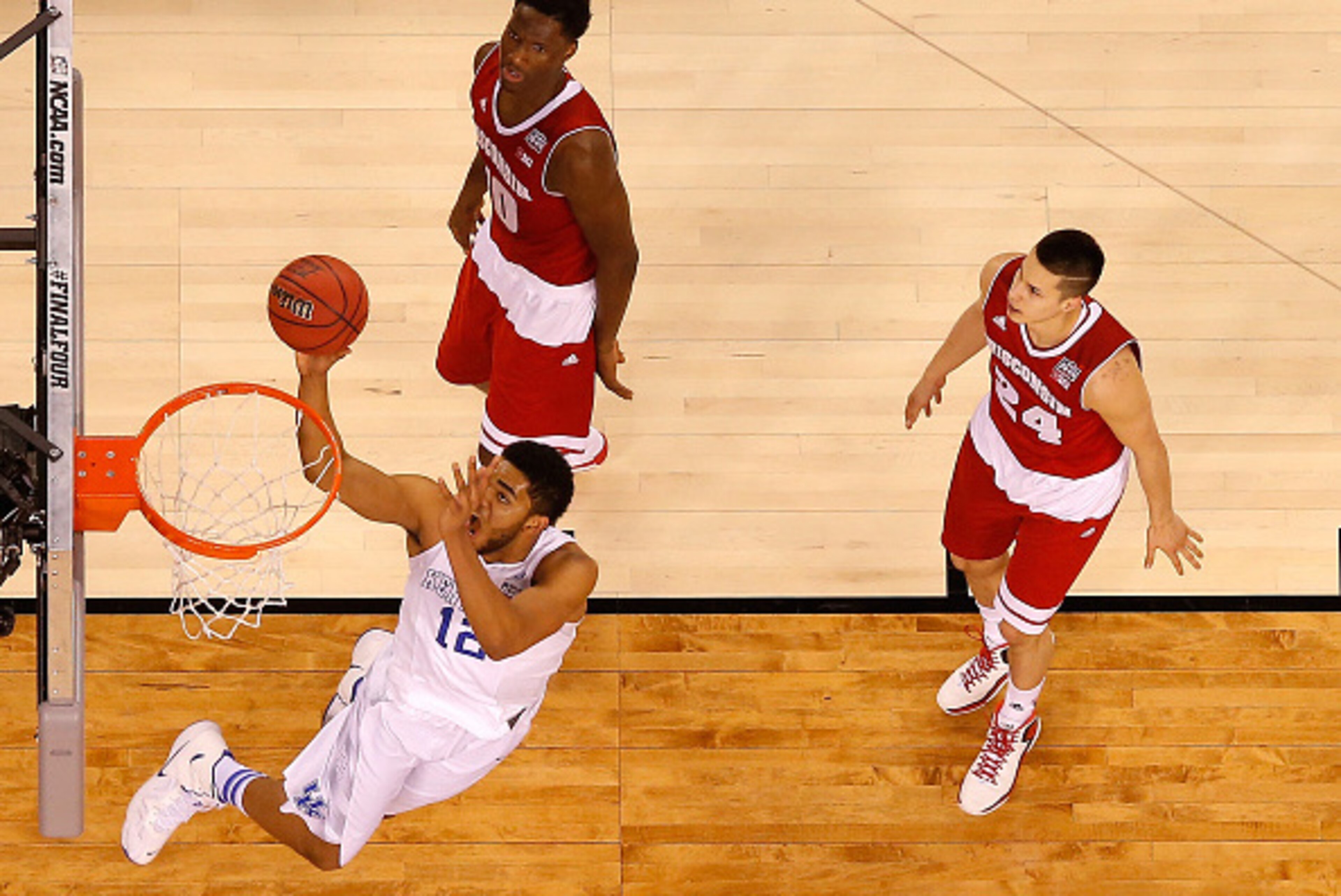 INDIANAPOLIS, IN - APRIL 04: Karl-Anthony Towns #12 of the Kentucky Wildcats drives to the basket in the second half against Nigel Hayes #10 and Bronson Koenig #24 of the Wisconsin Badgers during the NCAA Men's Final Four Semifinal at Lucas Oil Stadium on