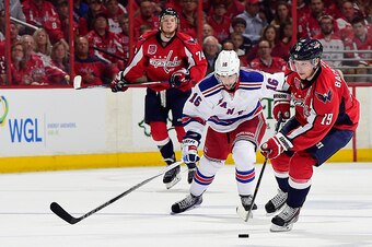 WASHINGTON, DC - MAY 06:  Nicklas Backstrom #19 of the Washington Capitals moves the puck up ice against Derick Brassard #16 of the New York Rangers during the second period in Game Four of the Eastern Conference Semifinals during the 2015 NHL Stanley Cup
