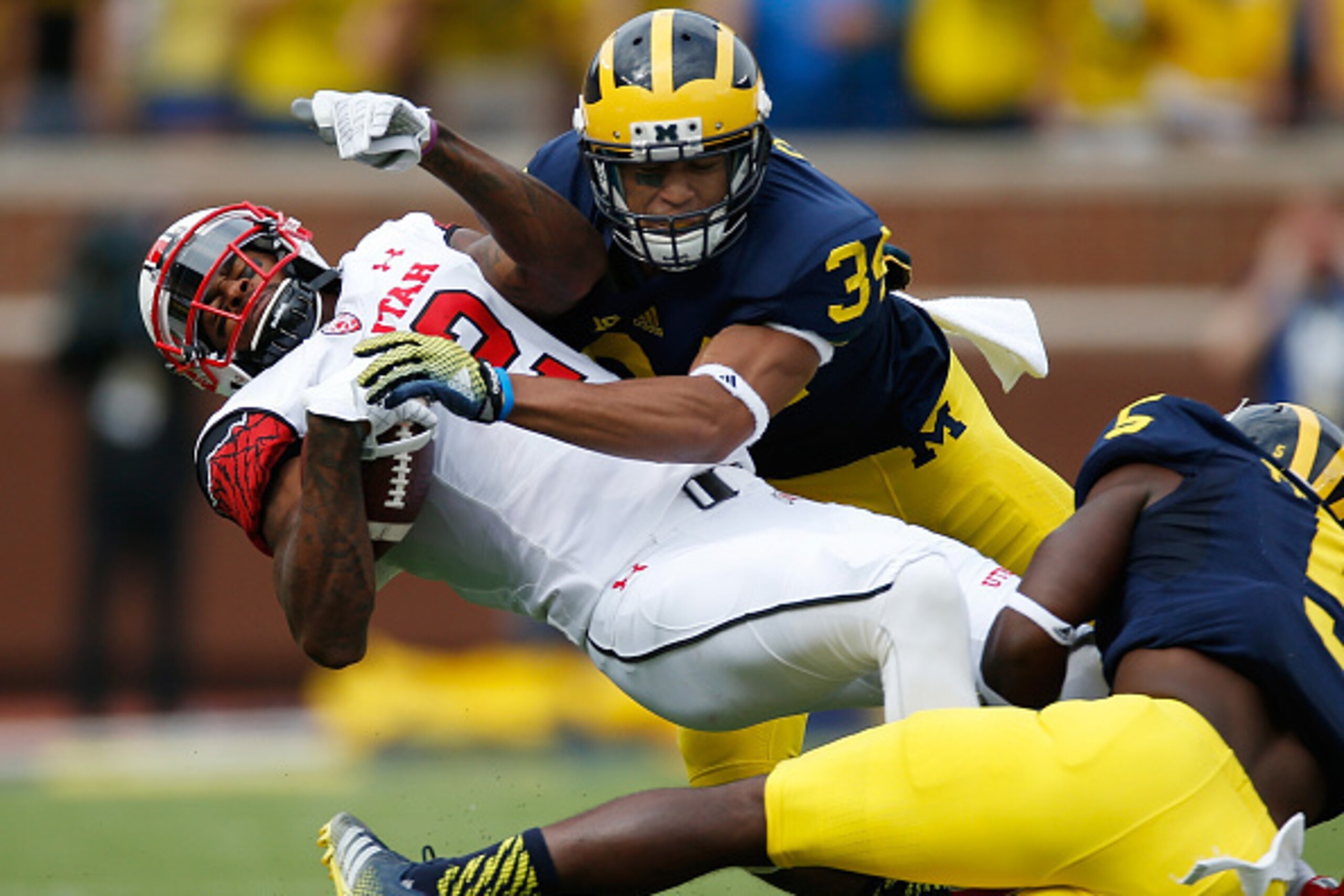ANN ARBOR, MI - SEPTEMBER 20:  Kenneth Scott #2 of the Utah Utes tries to battle for extra yards after a first quarter catch between Jeremy Clark #34 and Jabrill Peppers #5 of the Michigan Wolverines on September 20, 2014 at Michigan Stadium in Ann Arbor,
