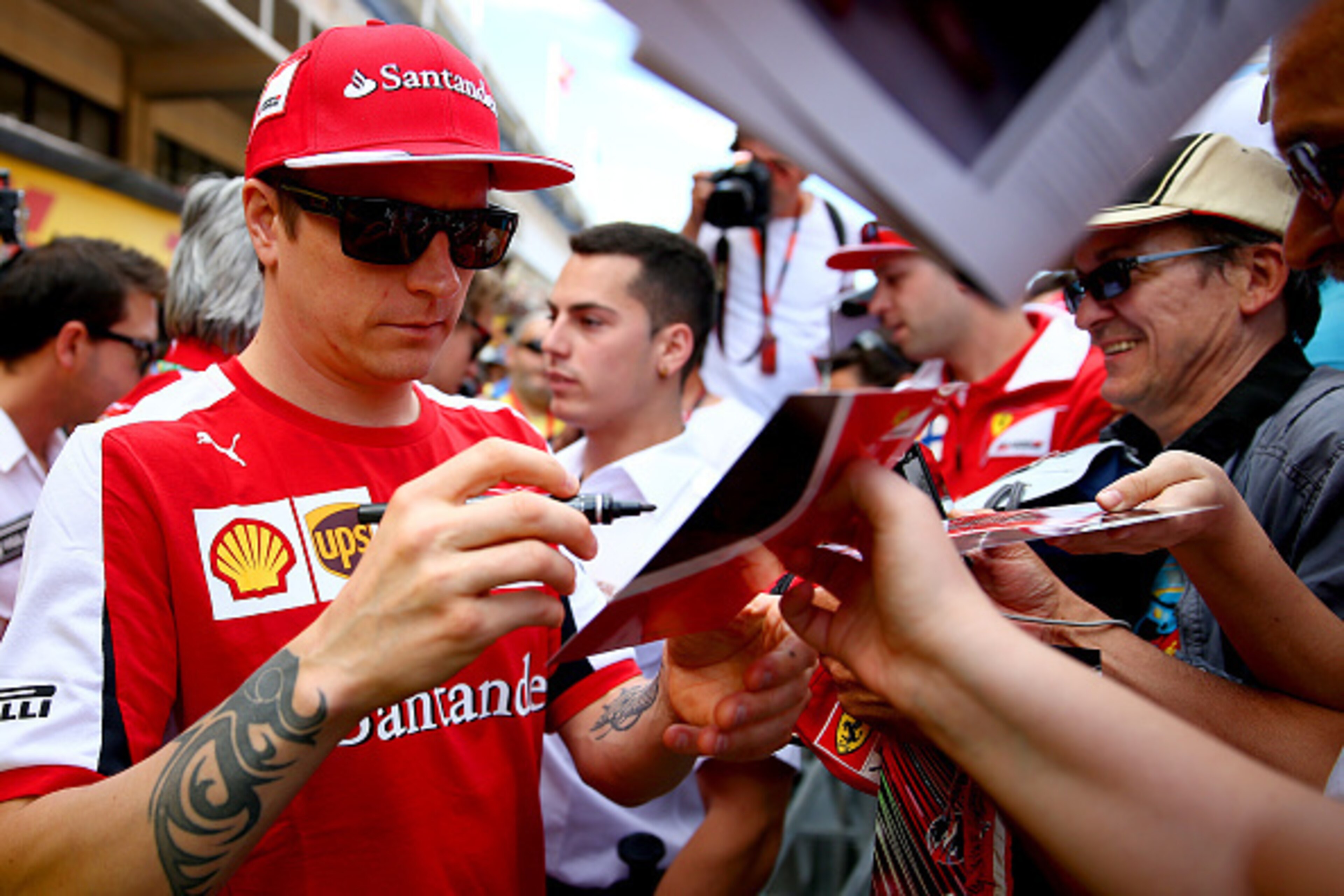 MONTMELO, SPAIN - MAY 07:  Kimi Raikkonen of Finland and Ferrari signs autographs for fans in the pit lane during previews to the Spanish Formula One Grand Prix at Circuit de Catalunya on May 7, 2015 in Montmelo, Spain.  (Photo by Clive Mason/Getty Images