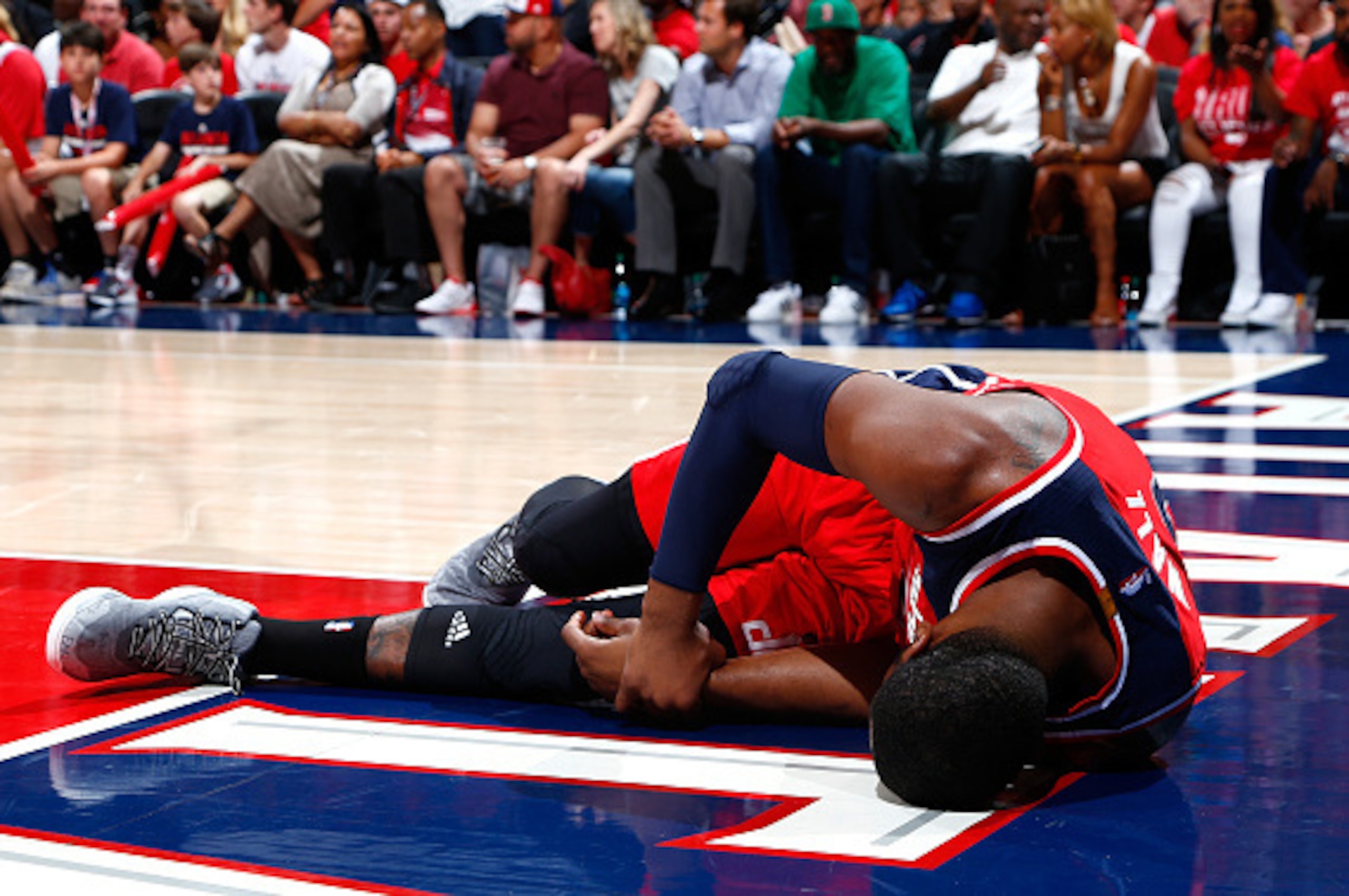 ATLANTA, GA - MAY 03:  John Wall #2 of the Washington Wizards grabs his wrist after missing a basket and landing on the floor against the Atlanta Hawks during Game One of the Eastern Conference Semifinals of the 2015 NBA Playoffs at Philips Arena on May 3