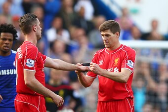 LONDON, ENGLAND - MAY 10:  Steven Gerrard of Liverpool hands the captain's armband to Jordan Henderson of Liverpool as he is substiytuted in the second half during the Barclays Premier League match between Chelsea and Liverpool at Stamford Bridge on May 1