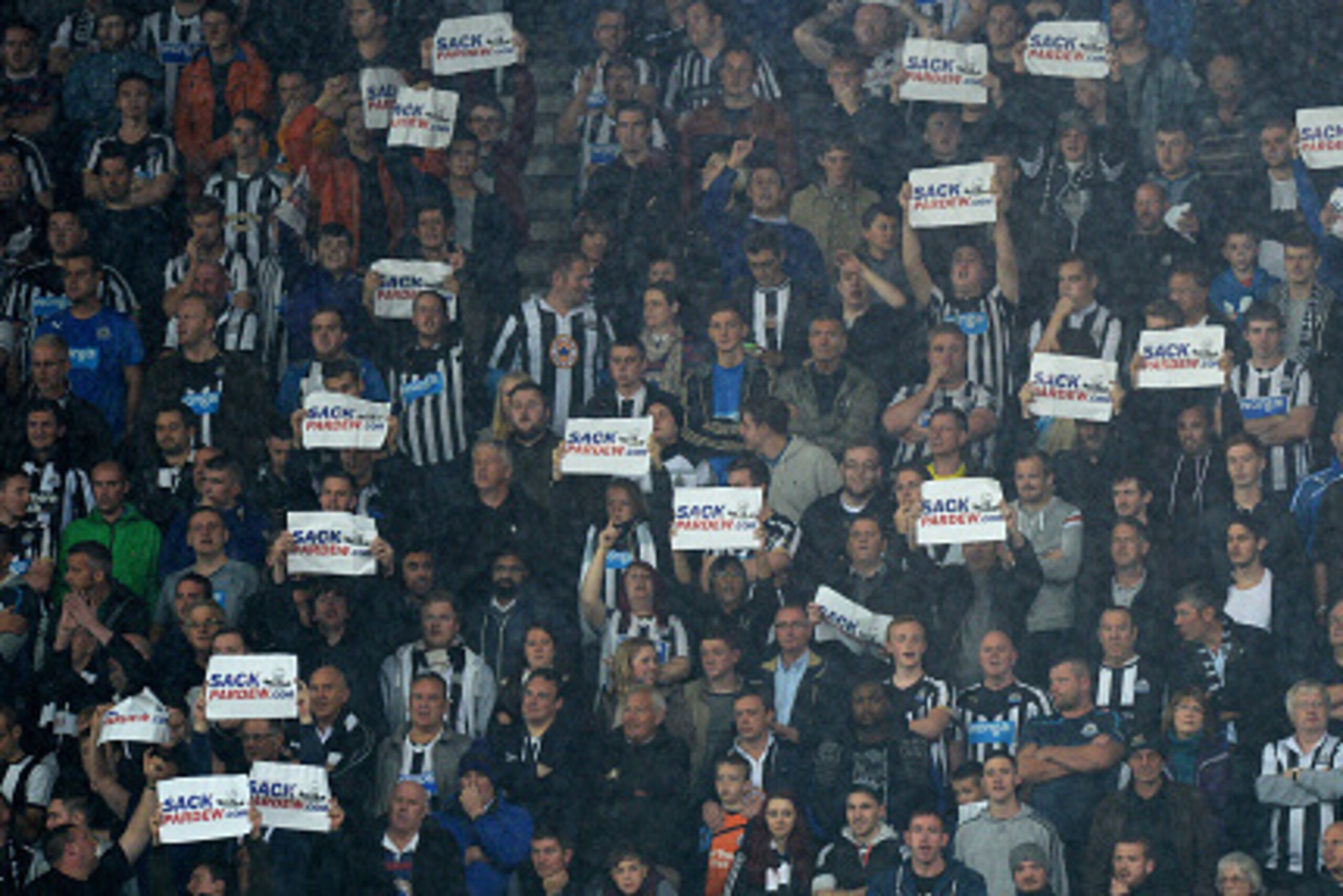 STOKE ON TRENT, ENGLAND - SEPTEMBER 29:  Newcastle fans hold up signs calling for Alan Pardew, manager of Newcastle United, to be sacked as they watch the Barclays Premier League match between Stoke City and Newcastle United at Britannia Stadium on Septem