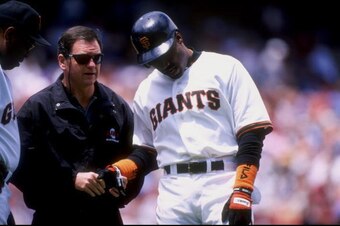 SAN FRANCISCO, CA - JUNE 28: Outfielder Barry Bonds #25 of the San Francisco Giants is checked out by the team trainer Stan Conte during an interleague game against the Texas Rangers on June 28, 1998 at 3COM Park in San Francisco, California. The Giants w