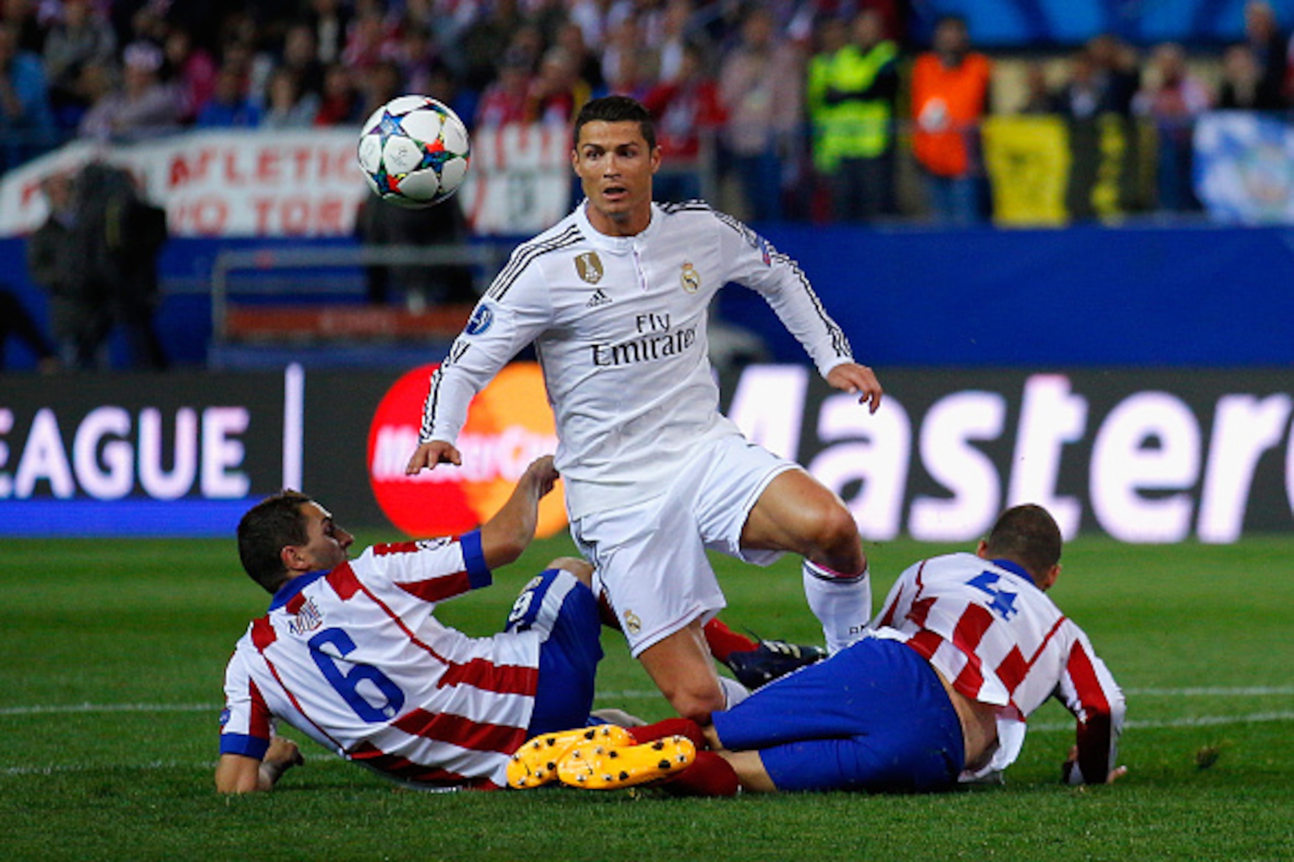 MADRID, SPAIN - APRIL 14:  Cristiano Ronaldo of Real Madrid CF is tackled by Koke of Atletico Madrid and Mario Suarez of Atletico Madrid during the UEFA Champions League Quarter Final First Leg match between Club Atletico de Madrid and Real Madrid CF at V