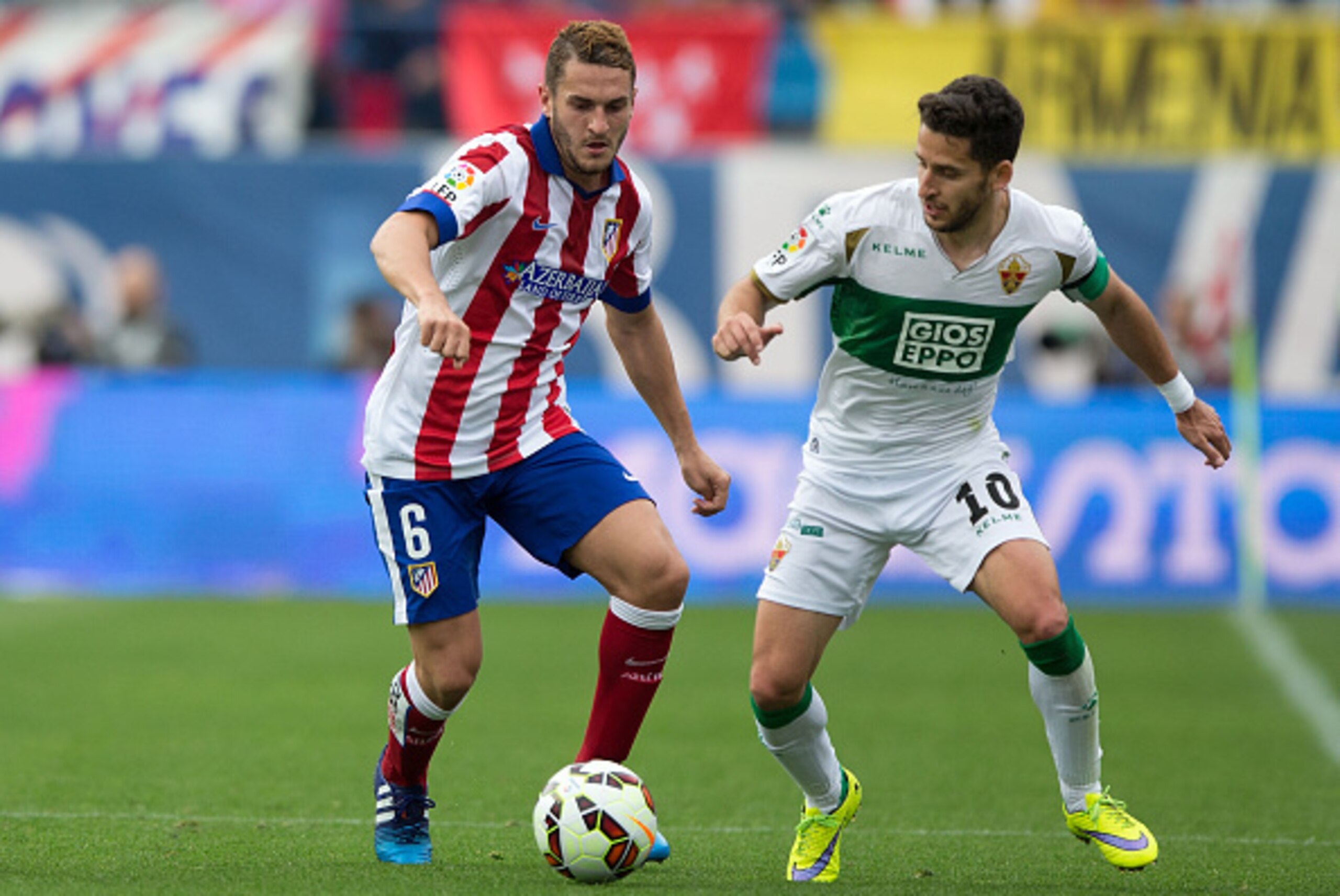 MADRID, SPAIN - APRIL 25: Koke (L) of Atletico de Madrid competes for the ball with Ferran Corominas (R) of Elche FC during the La Liga match between Club Atletico de Madrid and Elche FC at Vicente Calderon Stadium on April 25, 2015 in Madrid, Spain.  (Ph