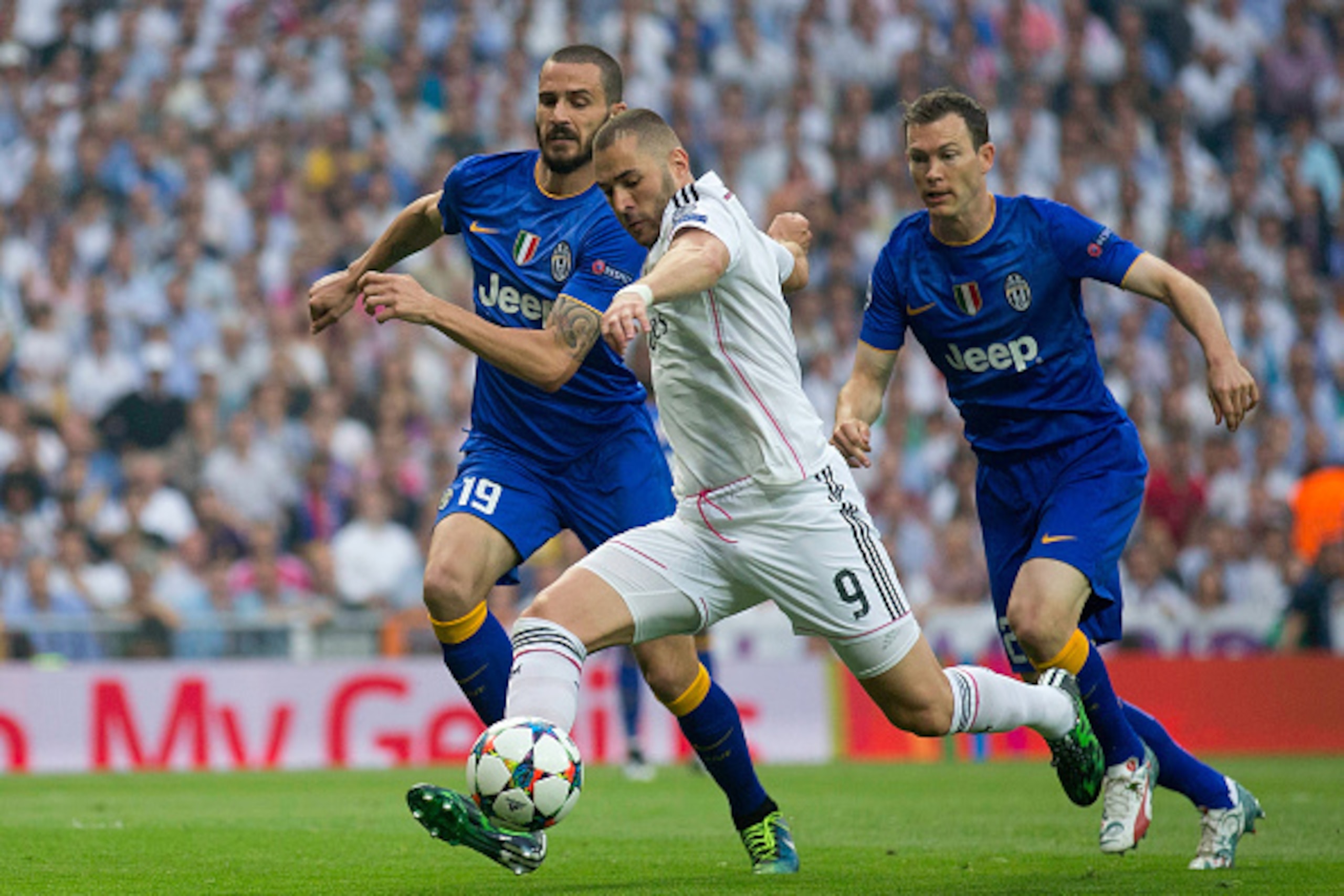 MADRID, SPAIN - MAY 13:  Karim Benzema of Real Madrid takes a shot on goal under pressure from Leonardo Bonucci of Juventus during the UEFA Champions League Semi Final, second leg match between Real Madrid and Juventus at Estadio Santiago Bernabeu on May 