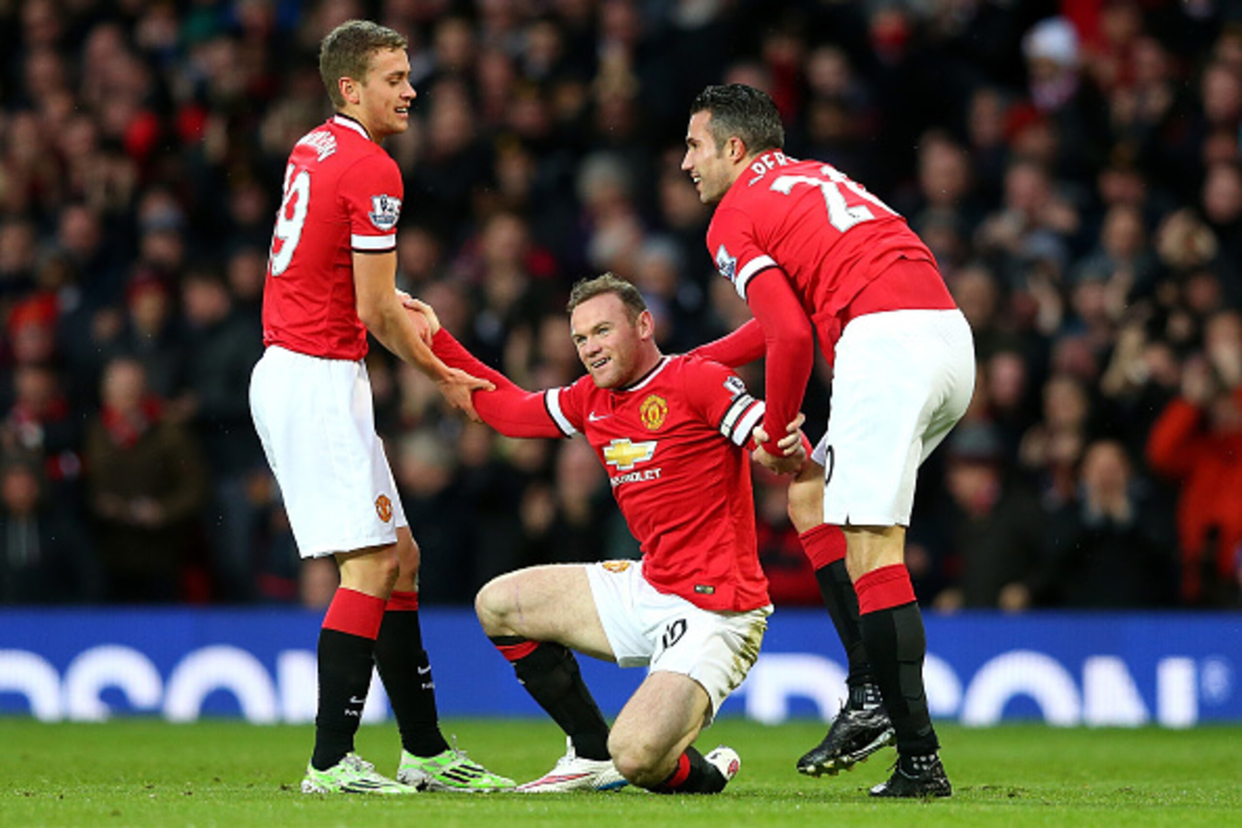 MANCHESTER, ENGLAND - DECEMBER 14:  Wayne Rooney of Manchester United is helped to his feet by James Wilson (L) and Robin van Persie (R) after scoring the first goal during the Barclays Premier League match between Manchester United and Liverpool at Old T