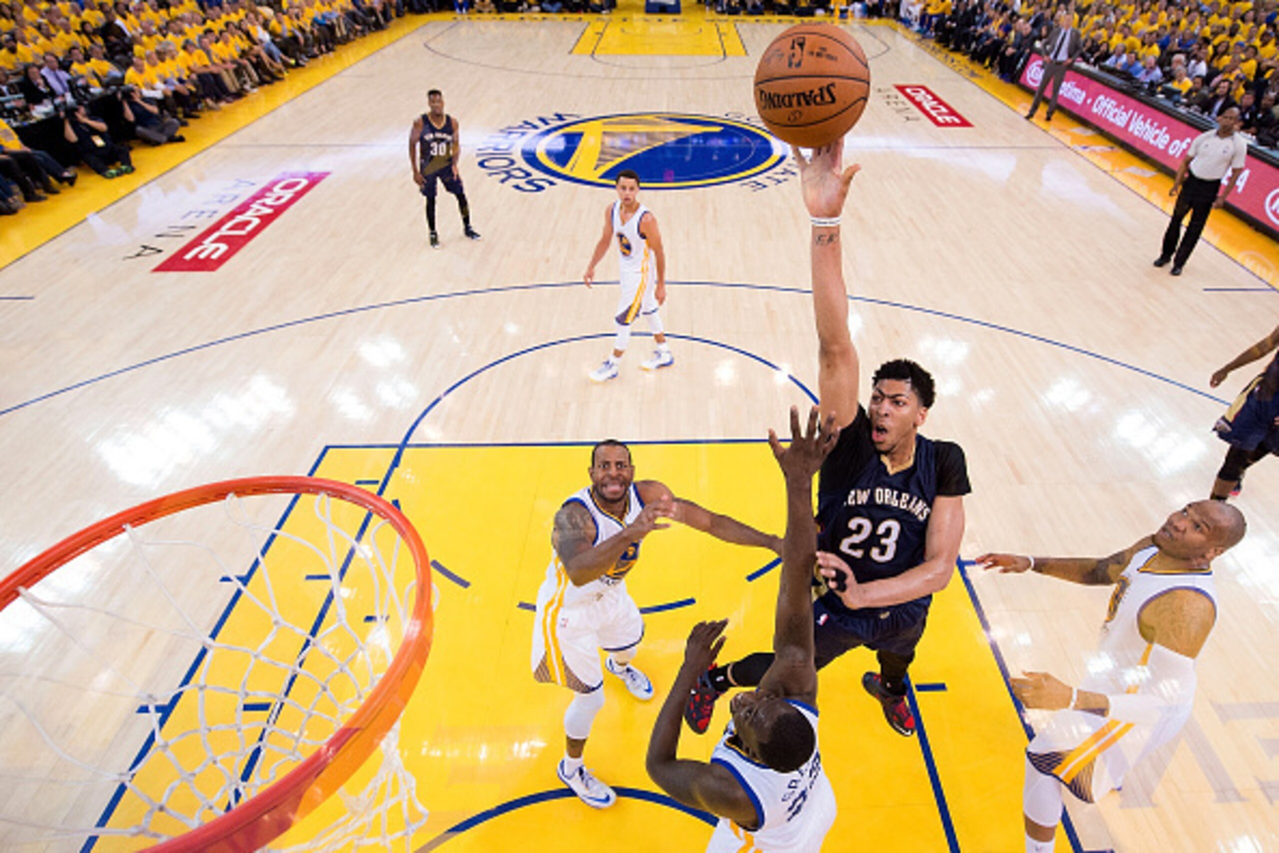 OAKLAND, CA - APRIL 20:  Anthony Davis #23 of the New Orleans Pelicans shoots over Draymond Green #23 and Andrew Bogut #12 of the Golden State Warriors in the third second half during the first round of the 2015 NBA Playoffs at ORACLE Arena on April 20, 2