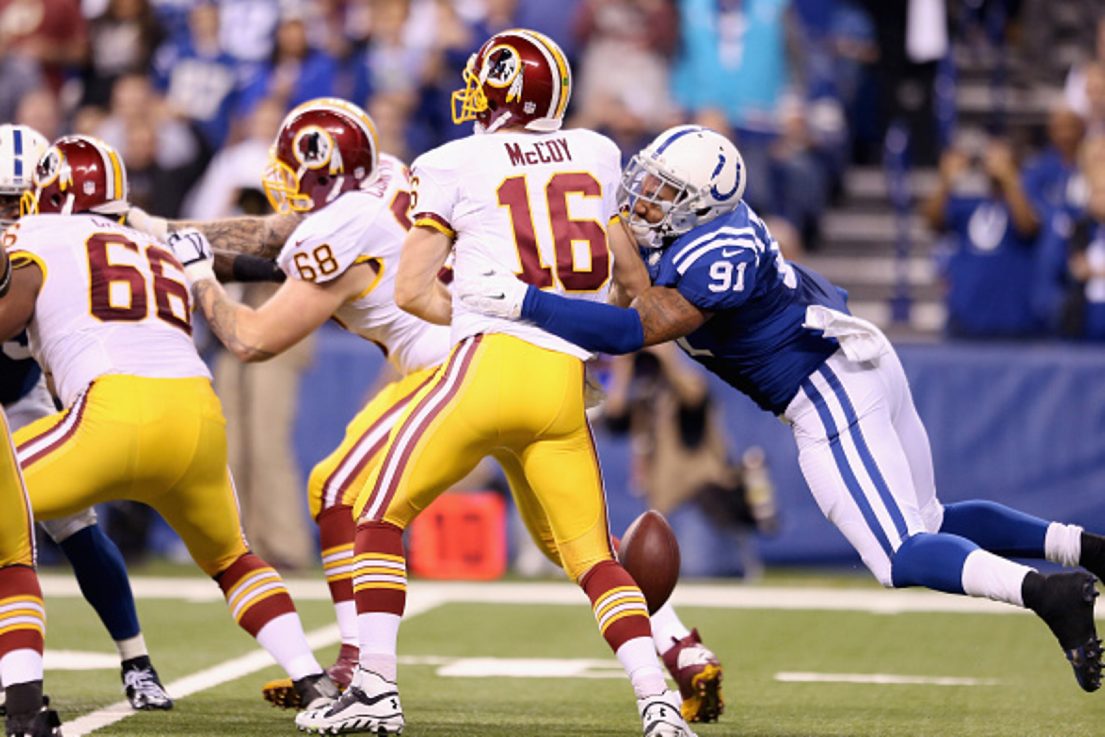 INDIANAPOLIS, IN - NOVEMBER 30:  Colt McCoy #16 of the Washington Redskins fumbles the ball as he is hit by Jonathan Newsome #91 of the Indianapolis Colts at Lucas Oil Stadium on November 30, 2014 in Indianapolis, Indiana.  (Photo by Andy Lyons/Getty Imag