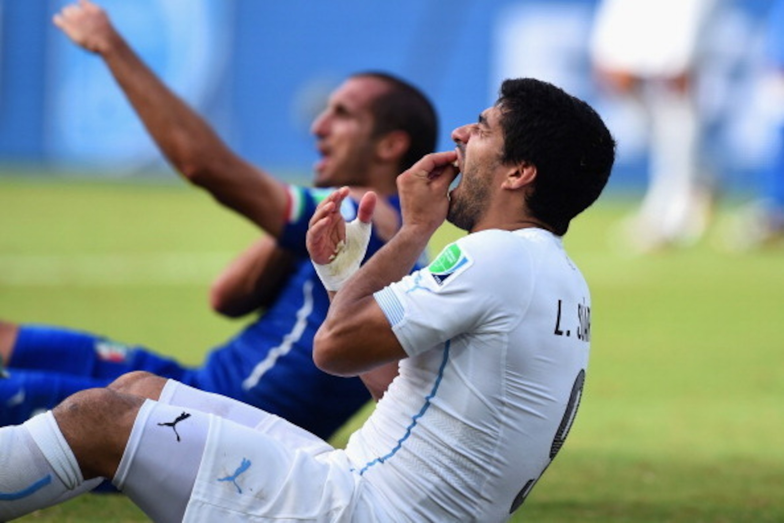 NATAL, BRAZIL - JUNE 24:  Luis Suarez of Uruguay and Giorgio Chiellini of Italy react after a clash during the 2014 FIFA World Cup Brazil Group D match between Italy and Uruguay at Estadio das Dunas on June 24, 2014 in Natal, Brazil.  (Photo by Matthias H