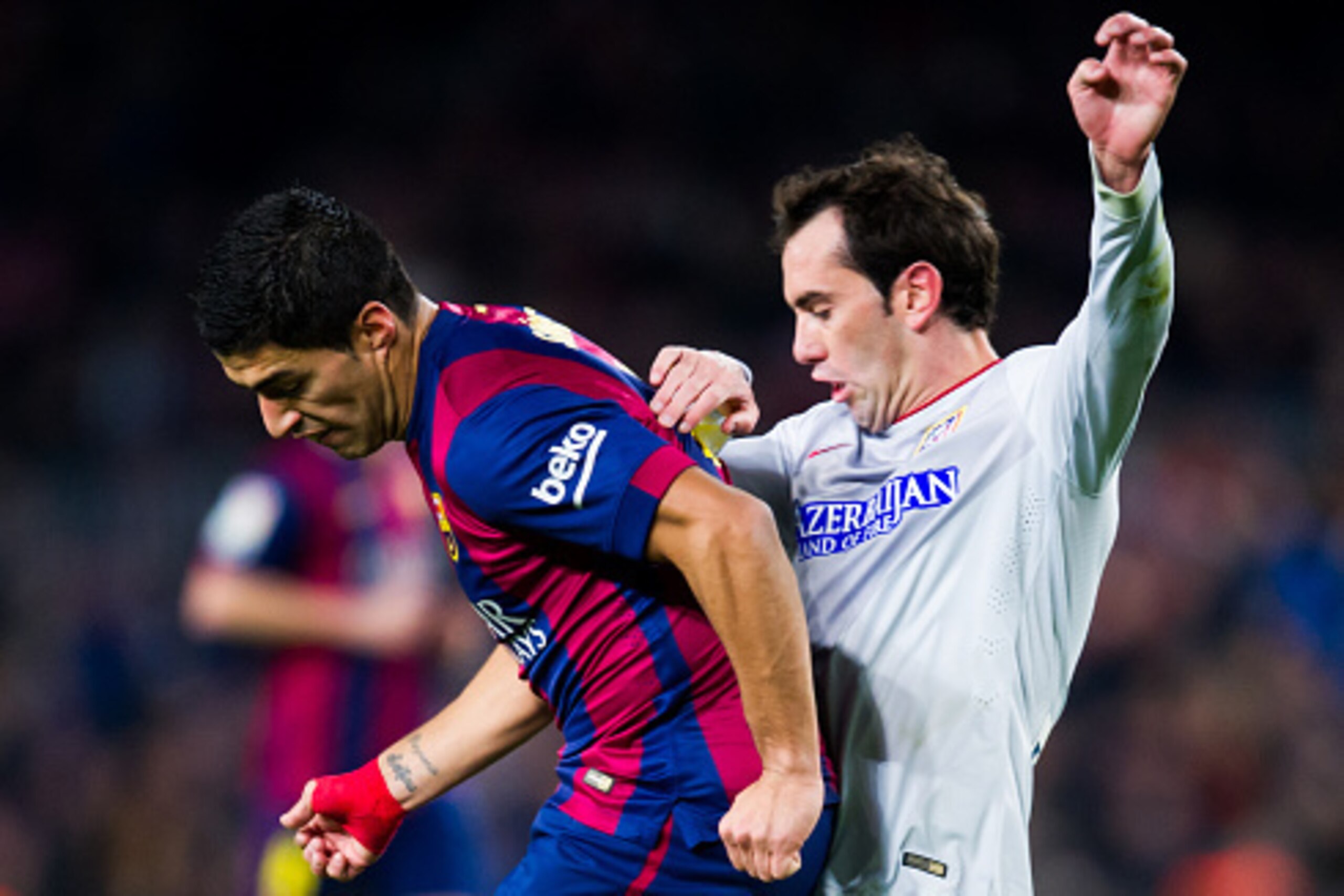 BARCELONA, SPAIN - JANUARY 21:  Luis Suarez of FC Barcelona fights for the ball with Diego Godin of Club Atletico de Madrid during the Copa del Rey Quarter-Final First Leg match between FC Barcelona and Club Atletico de Madrid at Camp Nou on January 21, 2
