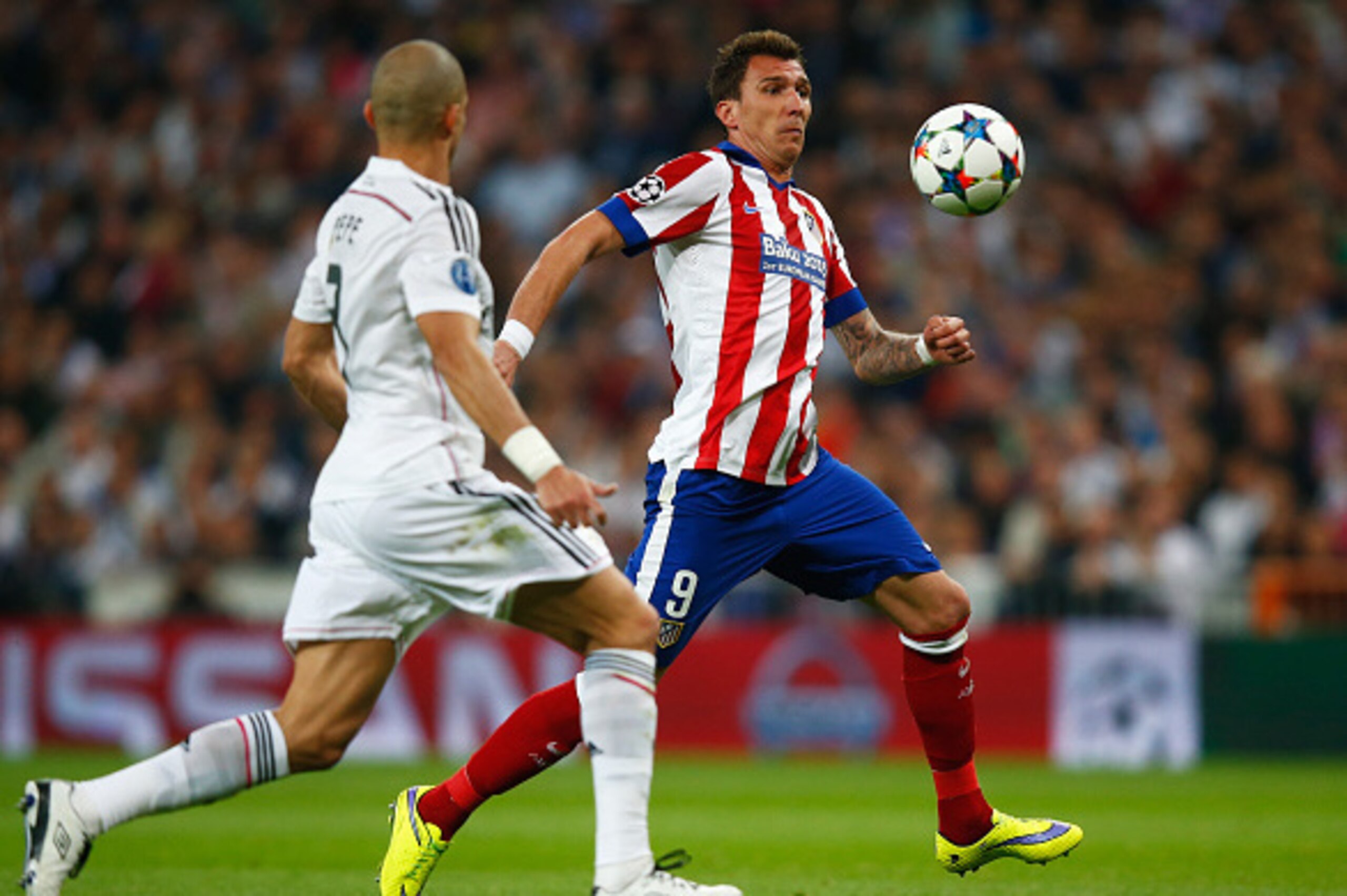 MADRID, SPAIN - APRIL 22:  Mario Mandzukic of Atletico Madrid takes on Pepe of Real Madrid CF during the UEFA Champions League quarter-final second leg match between Real Madrid CF and Club Atletico de Madrid at Bernabeu on April 22, 2015 in Madrid, Spain
