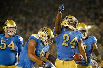 PASADENA, CA - SEPTEMBER 06:  Paul Perkins #24 of the UCLA Bruins celebrates his 17 yard touchdown run to take a 6-0 lead over the Memphis Tigers during the first half at Rose Bowl on September 6, 2014 in Pasadena, California.  (Photo by Harry How/Getty I