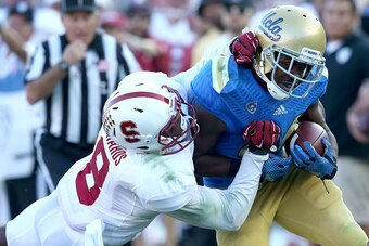 PASADENA, CA - NOVEMBER 28: Running back Paul Perkins #3 of the UCLA Bruins is pushed out of bounds by defensive back Jordan Richards #8 of the Stanford Cardinal at the Rose Bowl on November 28, 2014 in Pasadena, California. Stanford won 31-10.  (Photo by