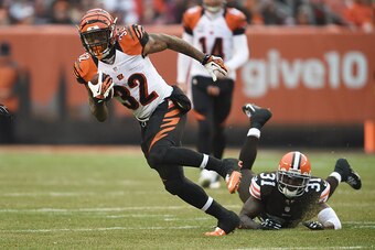 CLEVELAND, OH - DECEMBER 14:  Jeremy Hill #32 of the Cincinnati Bengals carries the ball in front of Donte Whitner #31 of the Cleveland Browns during the third quarter at FirstEnergy Stadium on December 14, 2014 in Cleveland, Ohio.  (Photo by Jason Miller