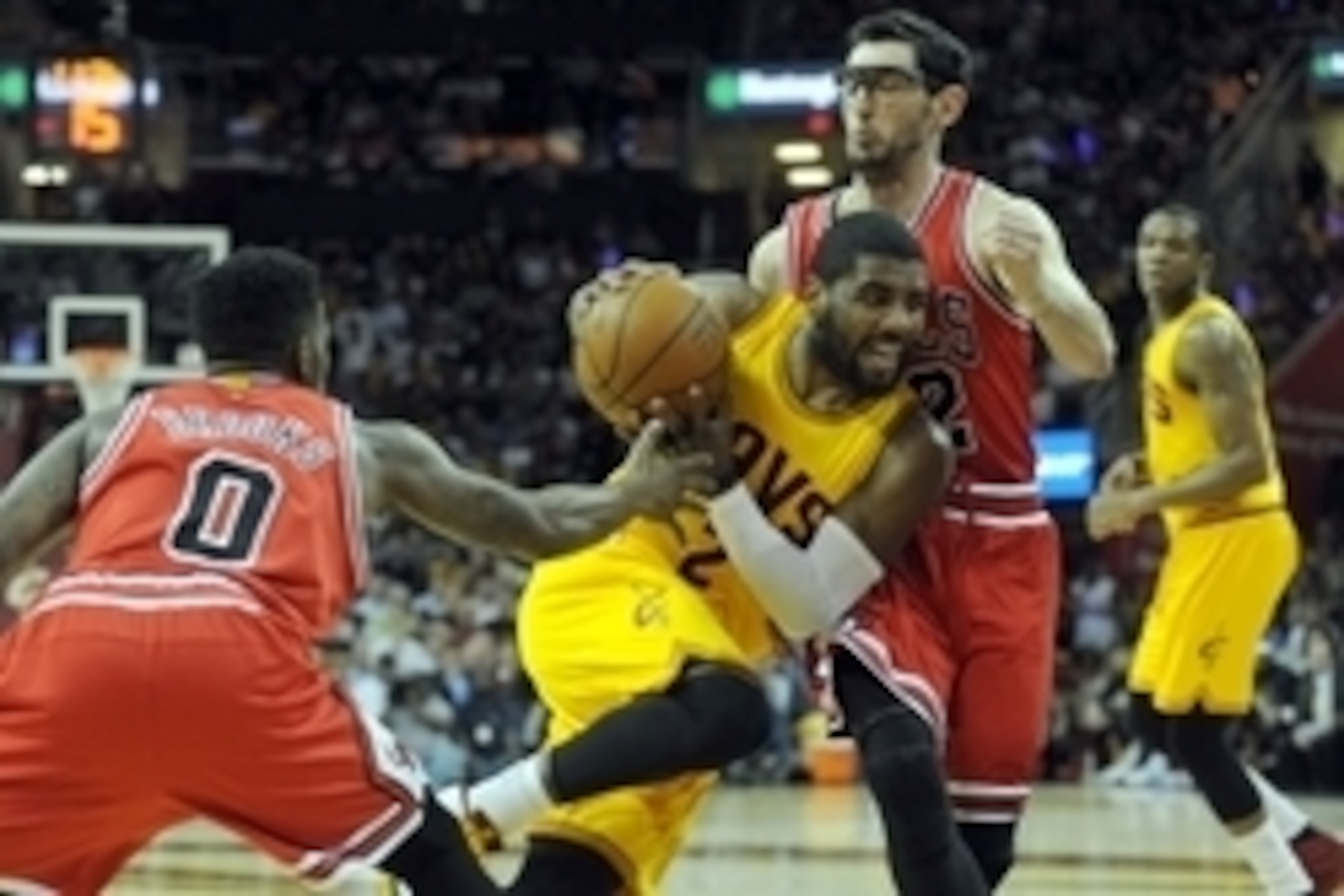 May 6, 2015; Cleveland, OH, USA; Cleveland Cavaliers guard Kyrie Irving (2) drives through Chicago Bulls guard Aaron Brooks (0) and  guard Kirk Hinrich (12) during the fourth quarter in game two of the second round of the NBA Playoffs at Quicken Loans Are