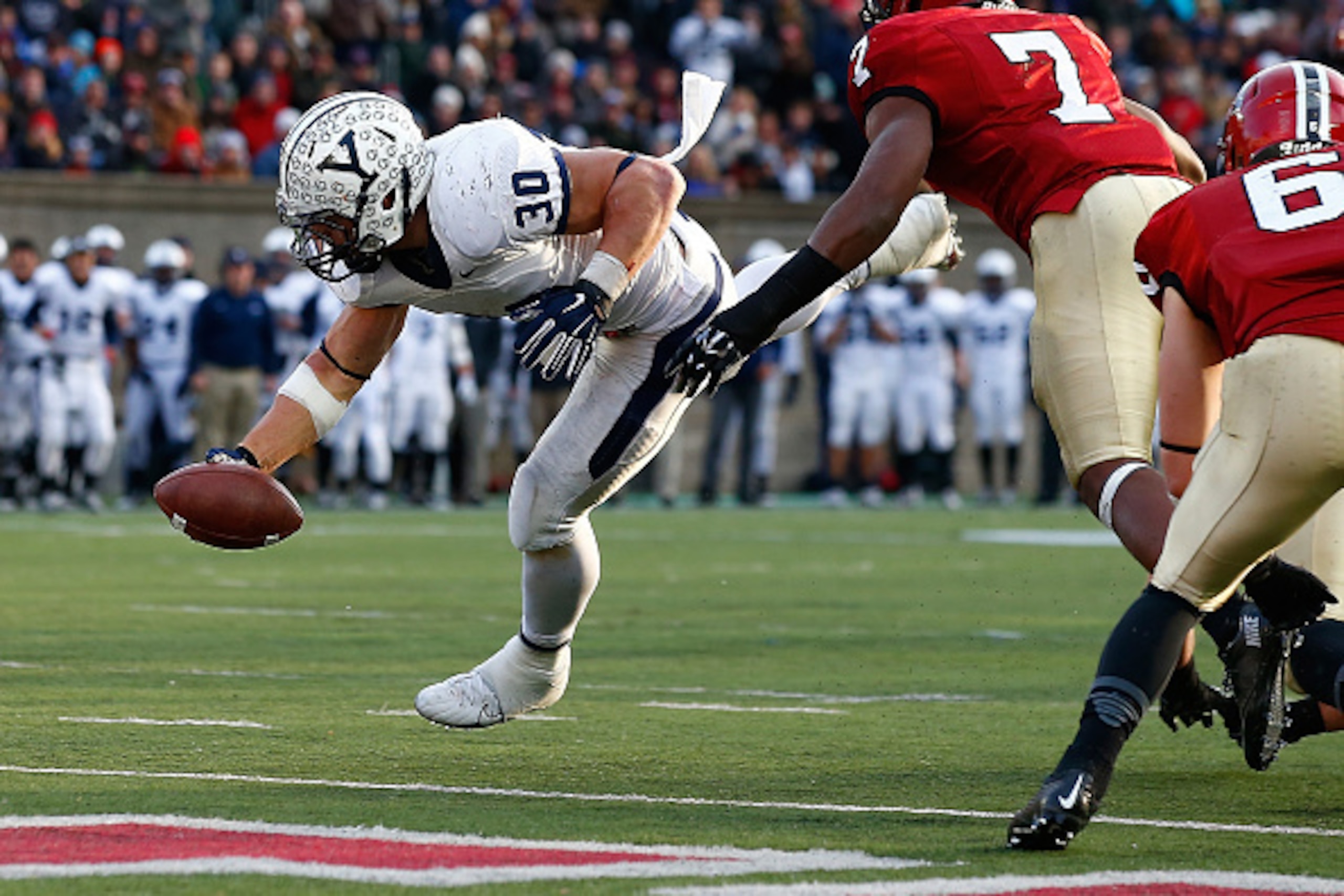 BOSTON, MA - NOVEMBER 22: Tyler Varga #30 of the Yale Bulldogs reaches for a touchdown in the second half past Norman Hayes #7 of the Harvard Crimson during the game at Harvard Stadium in their 131st meeting on November 22, 2014 in Boston, Massachusetts. 