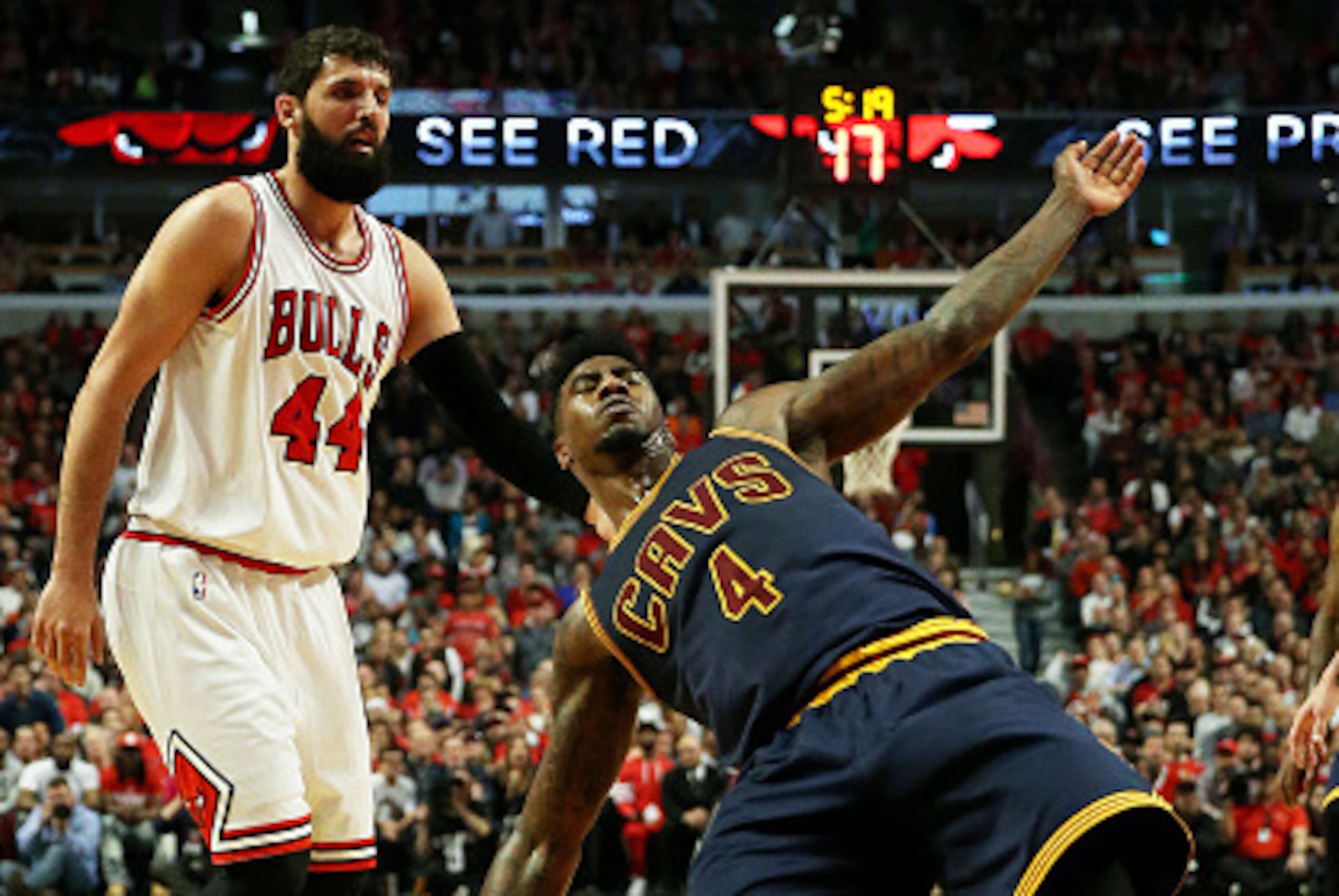 CHICAGO, IL - MAY 14:  Iman Shumpert #4 of the Cleveland Cavaliers falls ot the court as Nikola Mirotic #44 of the Chicago Bulls looks on in the second quarter during Game Six of the Eastern Conference Semifinals of the 2015 NBA Playoffs at United Center 