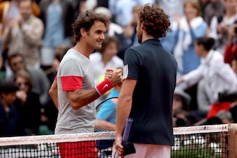 PARIS, FRANCE - JUNE 01:  Roger Federer of Switzerland shakes hands with Ernests Gulbis of Latvia at the net following his defeat in their men's singles match on day eight of the French Open at Roland Garros on June 1, 2014 in Paris, France.  (Photo by Ma