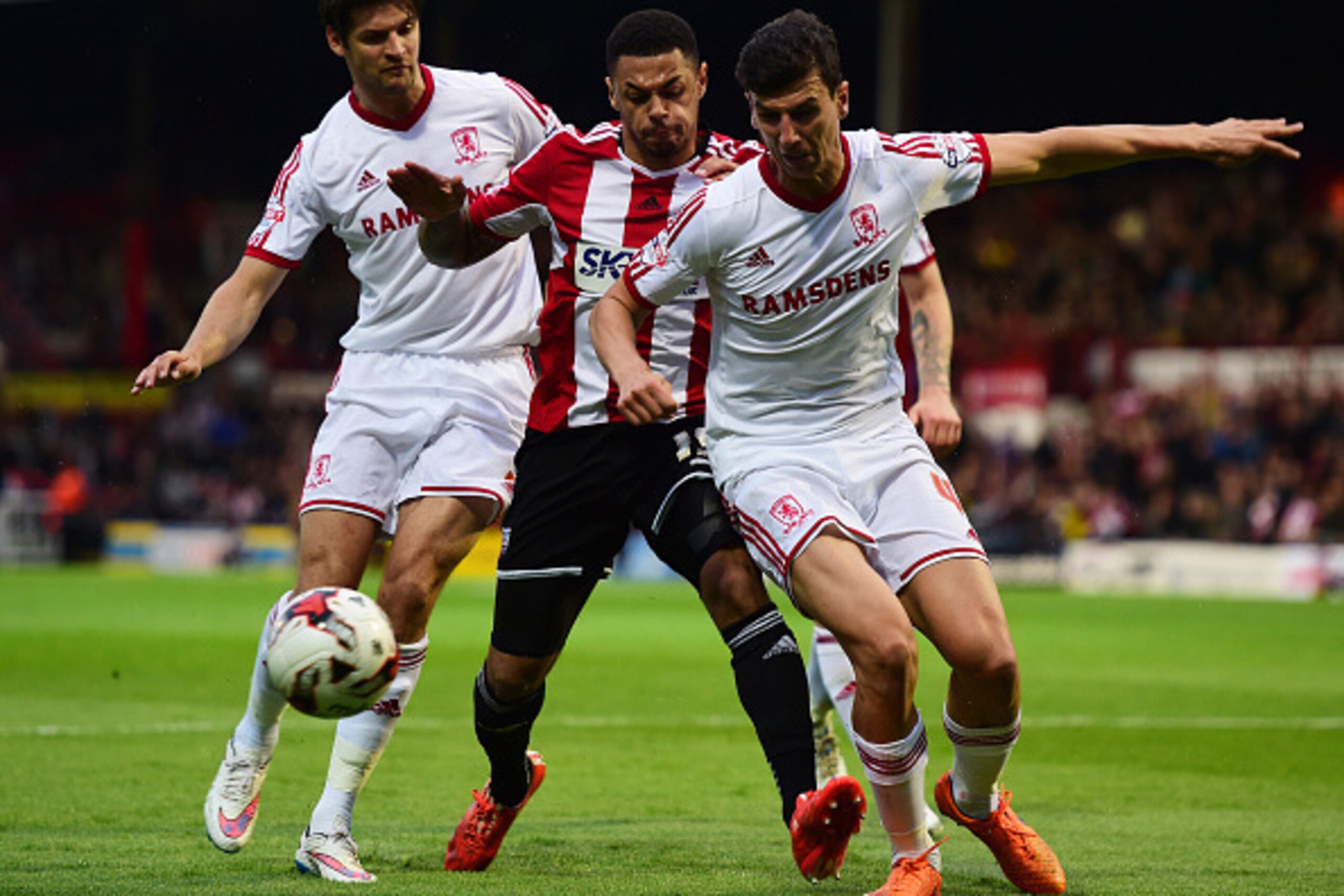 BRENTFORD, ENGLAND - MAY 08:  Andre Gray of Brentford (C) takes on Daniel Ayala (R) and George Friend of Middlesbrough (L) during the Sky Bet Championship Playoff semi-final first leg match between Brentford and Middlesbrough at Griffin Park on May 8, 201