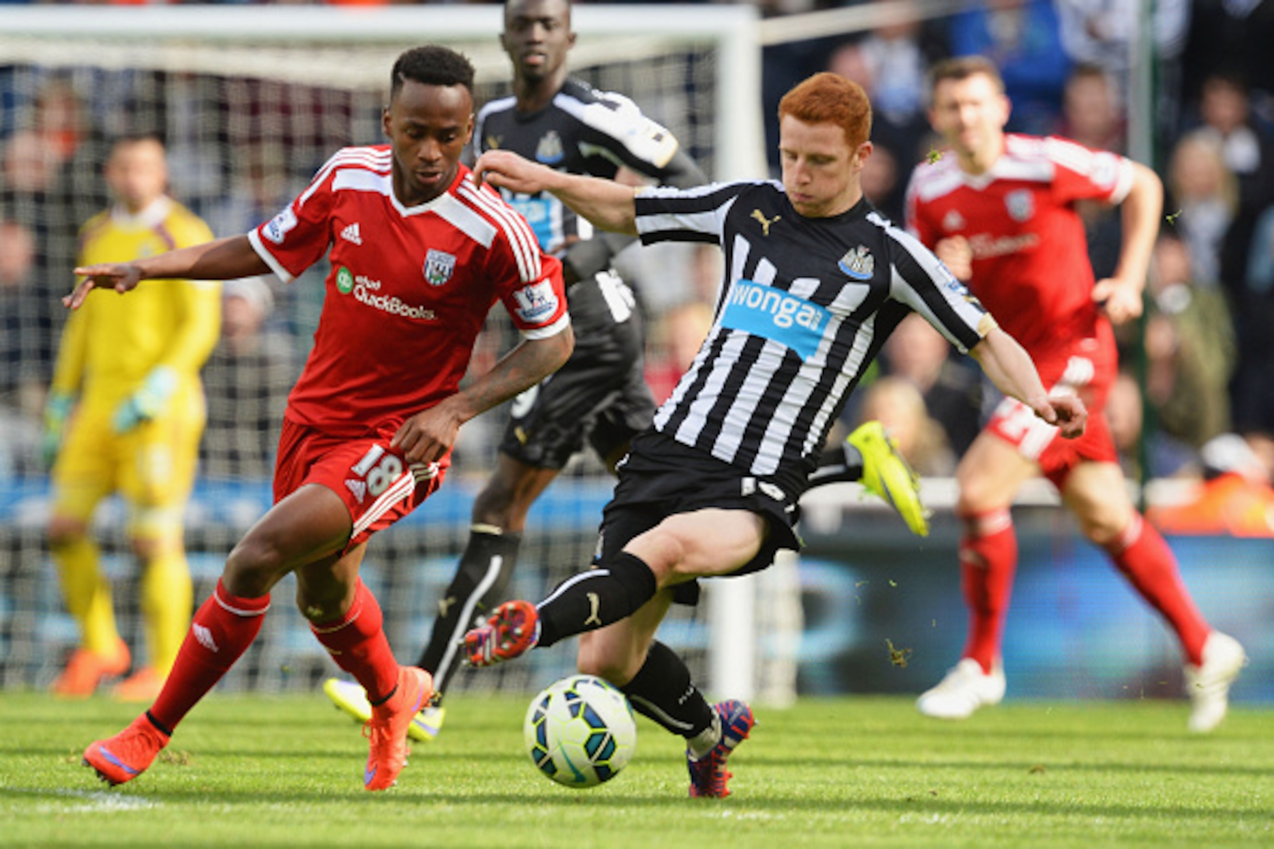 NEWCASTLE UPON TYNE, ENGLAND - MAY 09:  Saido Berahino of West Bromwich Albion and Jack Colback of Newcastle United battle for the ball during the Barclays Premier League match between Newcastle United and West Bromwich Albion at St James' Park on May 9, 