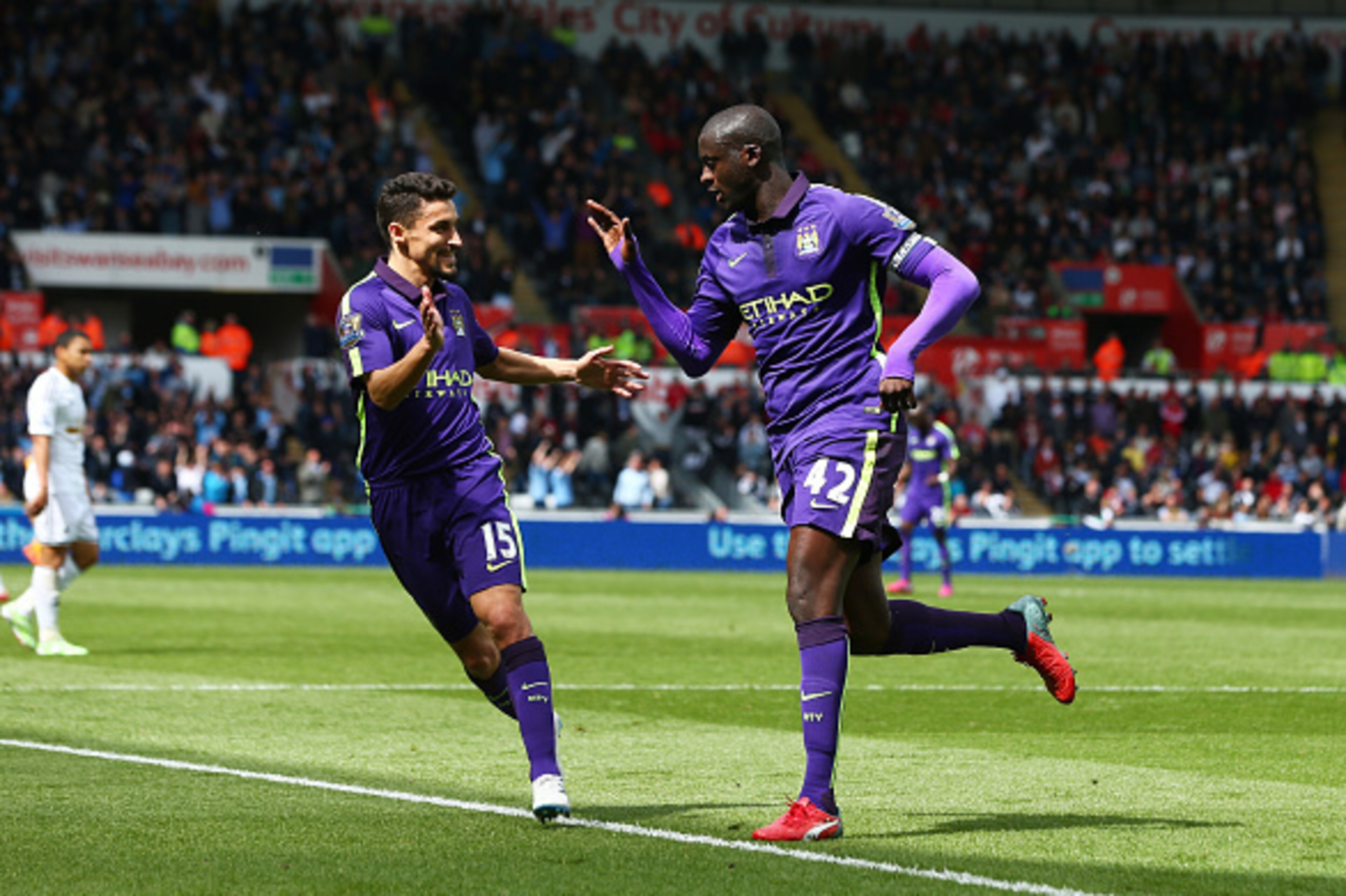 SWANSEA, WALES - MAY 17: Yaya Toure of Manchester City is congratulated by teammate Jesus Navas of Manchester City after scoring his team's third goal during the Barclays Premier League match between Swansea and Manchester City at the Liberty Stadium on SWANSEA, WALES - MAY 17: Yaya Toure of Manchester City is congratulated by teammate Jesus Navas of Manchester City after scoring his team's third goal during the Barclays Premier League match between Swansea and Manchester City at the Liberty Stadium on