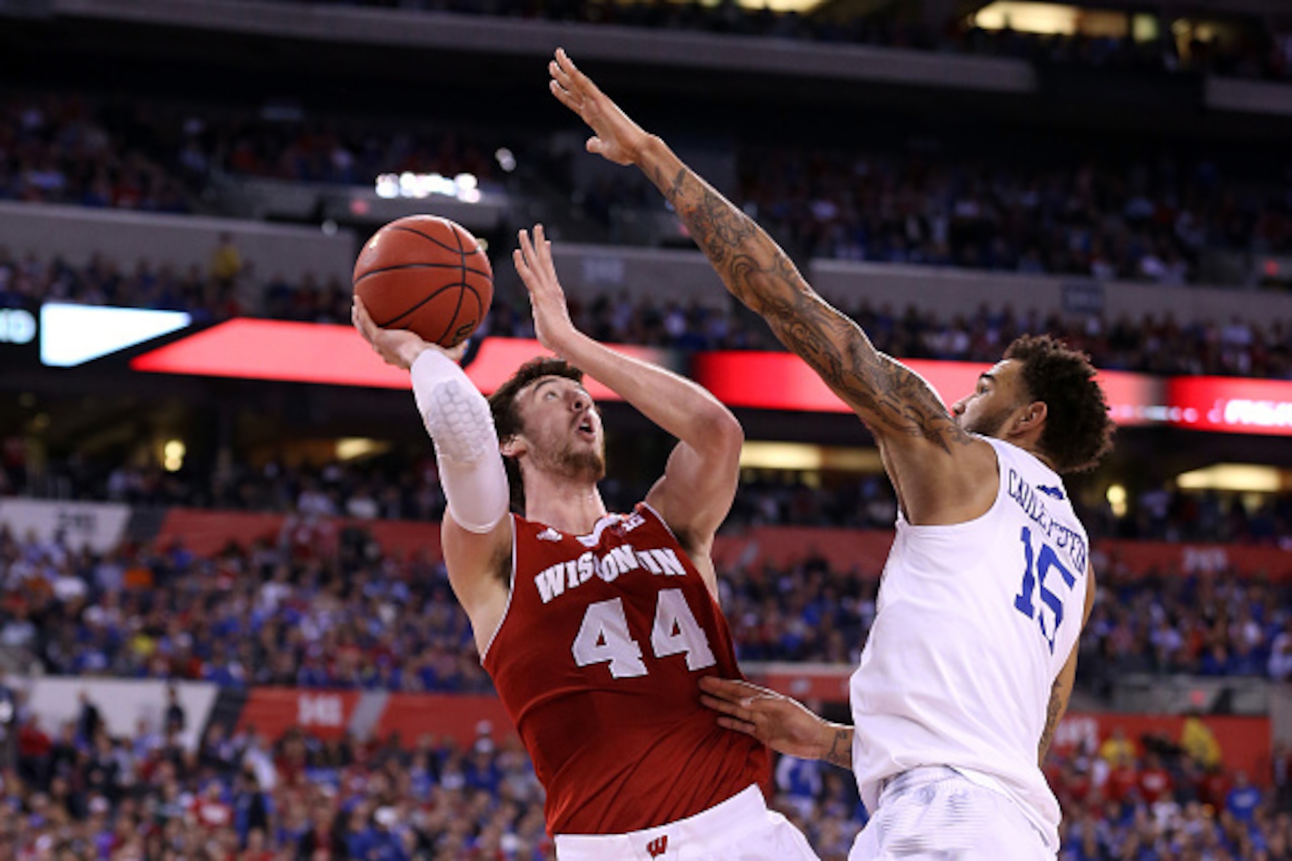 INDIANAPOLIS, IN - APRIL 04: Frank Kaminsky #44 of the Wisconsin Badgers shoots against Willie Cauley-Stein #15 of the Kentucky Wildcats in the second half during the NCAA Men's Final Four Semifinal at Lucas Oil Stadium on April 4, 2015 in Indianapolis, I