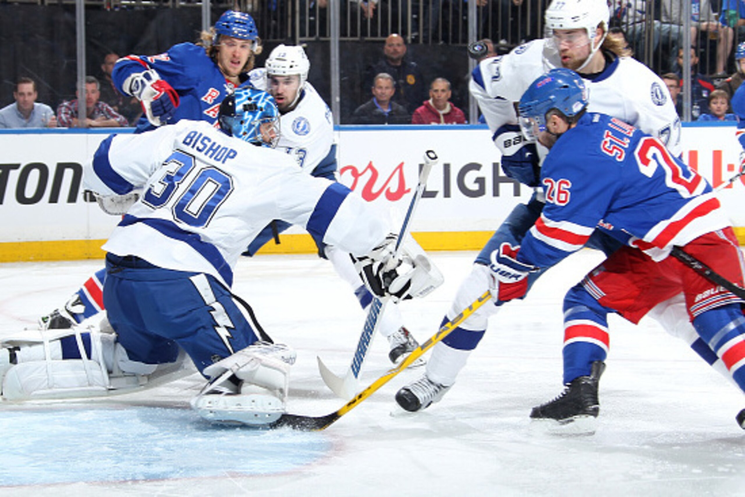 NEW YORK, NY - MAY 16:  Ben Bishop #30 of the Tampa Bay Lightning makes a save as Martin St. Louis #26 and Carl Hagelin #62 of the New York Rangers crash the net in Game One of the Eastern Conference Final during the 2015 NHL Stanley Cup Playoffs at Madis