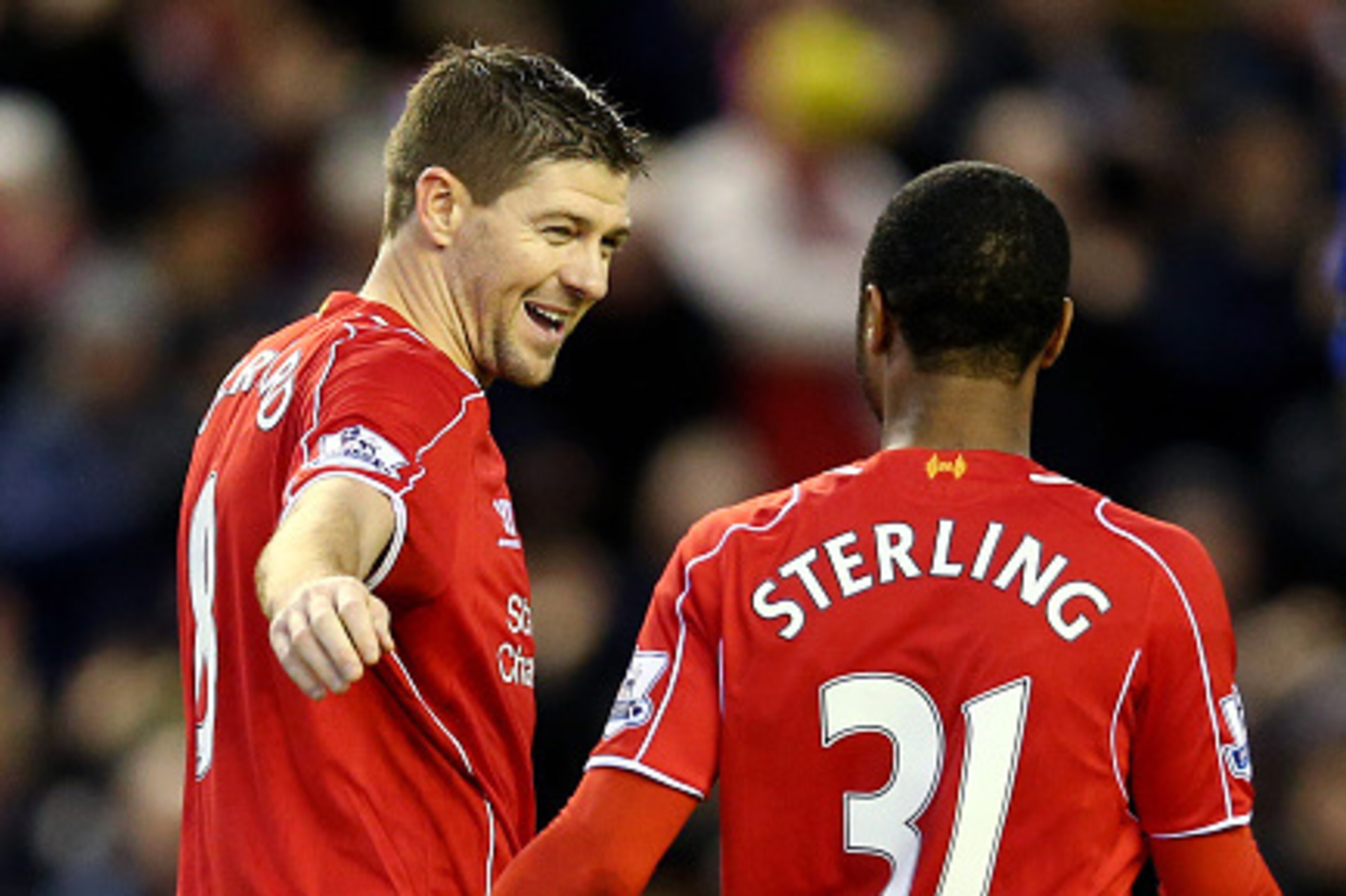 LIVERPOOL, ENGLAND - JANUARY 01:  Steven Gerrard of Liverpool celebrates with teammate Raheem Sterling of Liverpool after scoring his team's second goal from the penalty spot during the Barclays Premier League match between Liverpool and Leicester City at