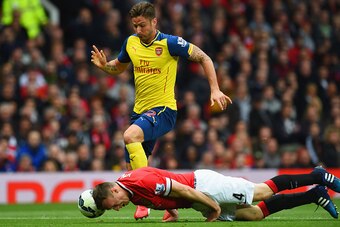 MANCHESTER, ENGLAND - MAY 17:  Phil Jones of Manchester United heads the ball clear of Olivier Giroud of Arsenal during the Barclays Premier League match between Manchester United and Arsenal at Old Trafford on May 17, 2015 in Manchester, England.  (Photo