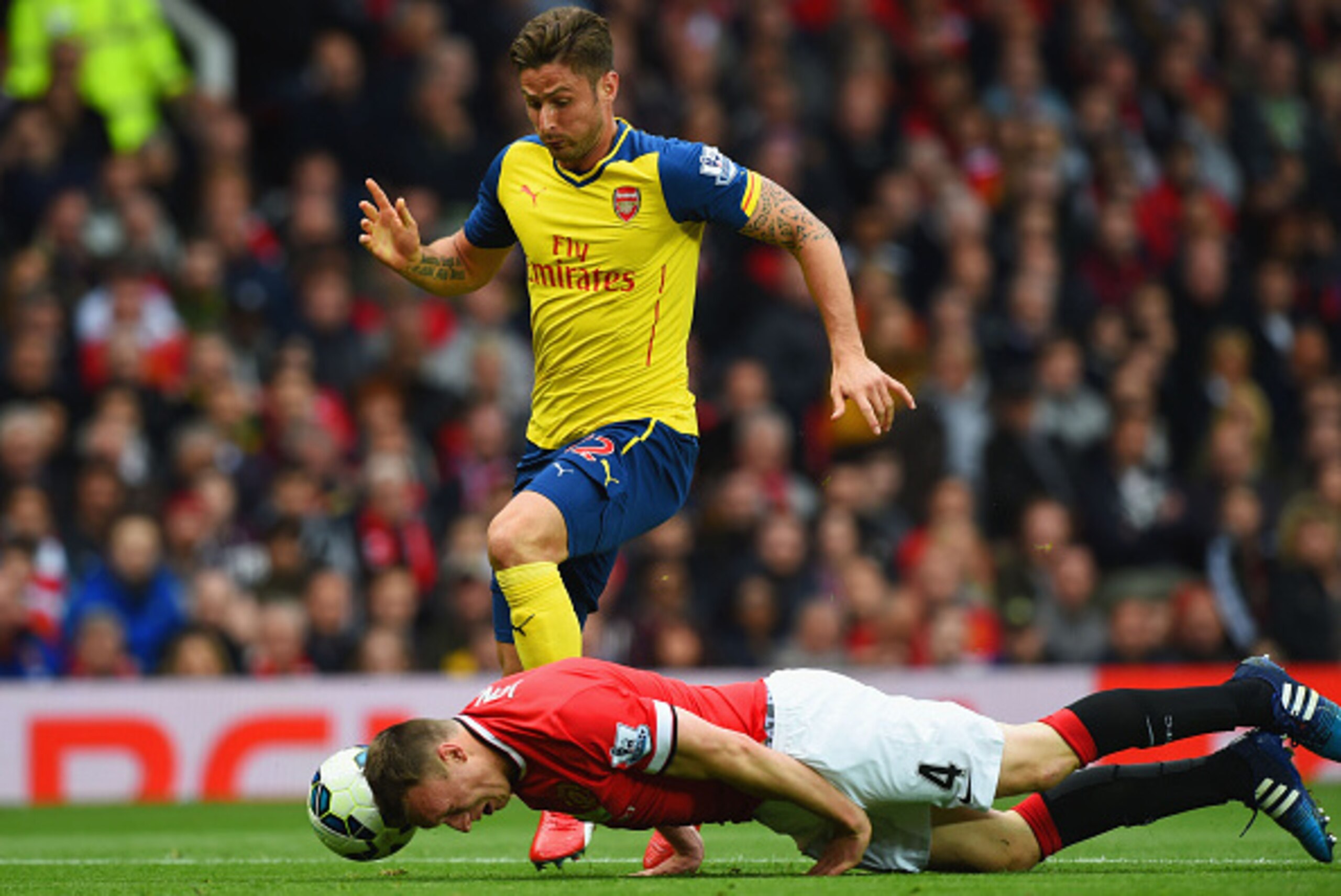 MANCHESTER, ENGLAND - MAY 17: Phil Jones of Manchester United heads the ball clear of Olivier Giroud of Arsenal during the Barclays Premier League match between Manchester United and Arsenal at Old Trafford on May 17, 2015 in Manchester, England. (Photo MANCHESTER, ENGLAND - MAY 17: Phil Jones of Manchester United heads the ball clear of Olivier Giroud of Arsenal during the Barclays Premier League match between Manchester United and Arsenal at Old Trafford on May 17, 2015 in Manchester, England. (Photo