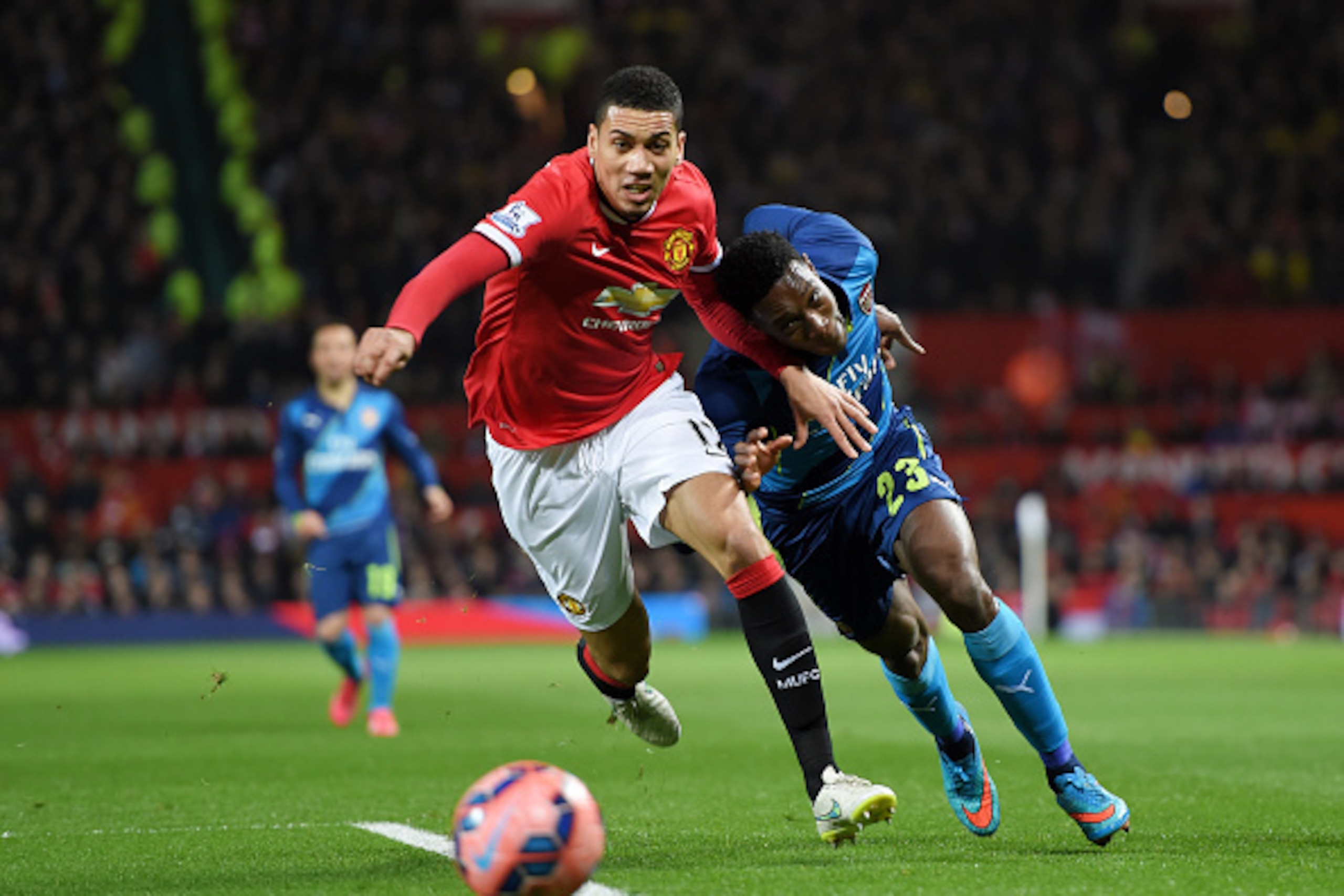 MANCHESTER, ENGLAND - MARCH 09:  Chris Smalling of Manchester United and Danny Welbeck of Arsenal battle for the ball during the FA Cup Quarter Final match between Manchester United and Arsenal at Old Trafford on March 9, 2015 in Manchester, England.  (Ph