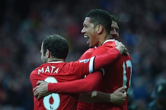 MANCHESTER, ENGLAND - APRIL 12:  Chris Smalling of Manchester United with celebrates with Juan Mata (L) and Michael Carrick (R) as he scores their fourth goal during the Barclays Premier League match between Manchester United and Manchester City at Old Tr