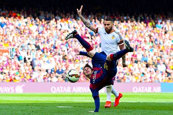 BARCELONA, SPAIN - APRIL 18:  Lionel Messi of FC Barcelona performs an overhead kick under a challenge by Nicolas Otamendi of Valencia CF during the La Liga match between FC Barcelona and Valencia CF at Camp Nou on April 18, 2015 in Barcelona, Spain.  (Ph