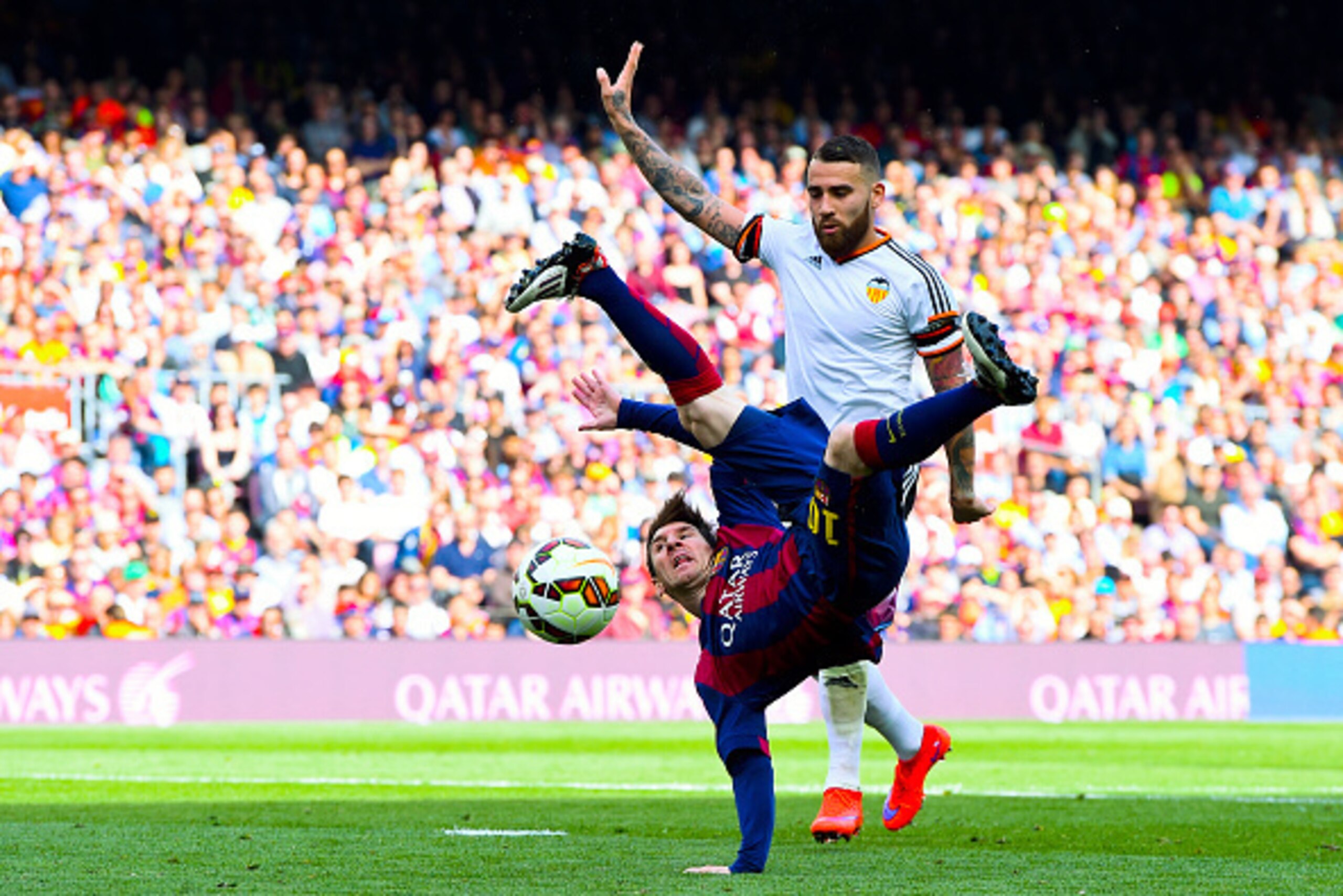 BARCELONA, SPAIN - APRIL 18:  Lionel Messi of FC Barcelona performs an overhead kick under a challenge by Nicolas Otamendi of Valencia CF during the La Liga match between FC Barcelona and Valencia CF at Camp Nou on April 18, 2015 in Barcelona, Spain.  (Ph