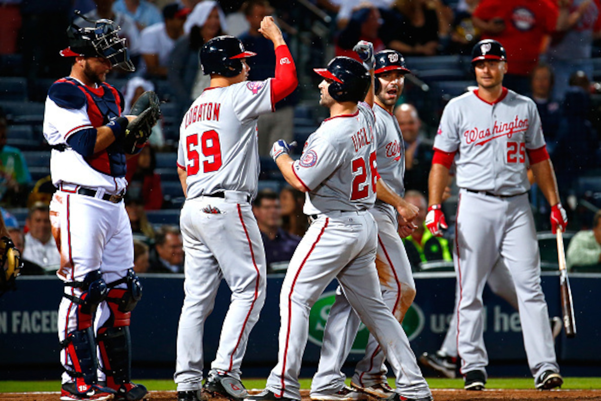 ATLANTA, GA - APRIL 28: Dan Uggla #26 of the Washington Nationals celebrates after hitting a three-run homer in the ninth inning to score Jose Lobaton #59 and Danny Espinosa #8 against the Atlanta Braves at Turner Field on April 28, 2015 in Atlanta, Geor ATLANTA, GA - APRIL 28: Dan Uggla #26 of the Washington Nationals celebrates after hitting a three-run homer in the ninth inning to score Jose Lobaton #59 and Danny Espinosa #8 against the Atlanta Braves at Turner Field on April 28, 2015 in Atlanta, Geor