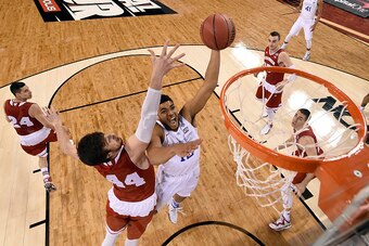 INDIANAPOLIS, IN - APRIL 04:  Karl-Anthony Towns #12 of the Kentucky Wildcats handles the ball against Frank Kaminsky #44 of the Wisconsin Badgers in the first half during the NCAA Men's Final Four Semifinal at Lucas Oil Stadium on April 4, 2015 in Indian