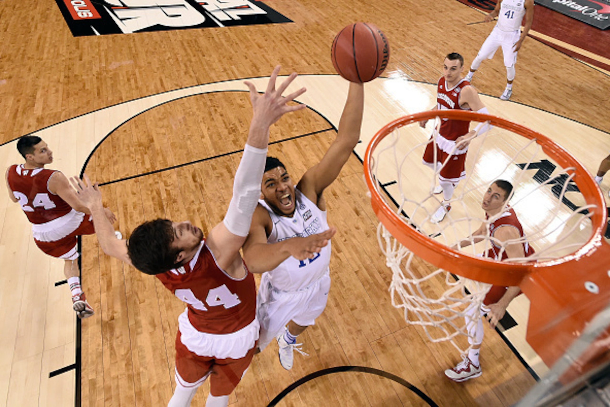 INDIANAPOLIS, IN - APRIL 04:  Karl-Anthony Towns #12 of the Kentucky Wildcats handles the ball against Frank Kaminsky #44 of the Wisconsin Badgers in the first half during the NCAA Men's Final Four Semifinal at Lucas Oil Stadium on April 4, 2015 in Indian
