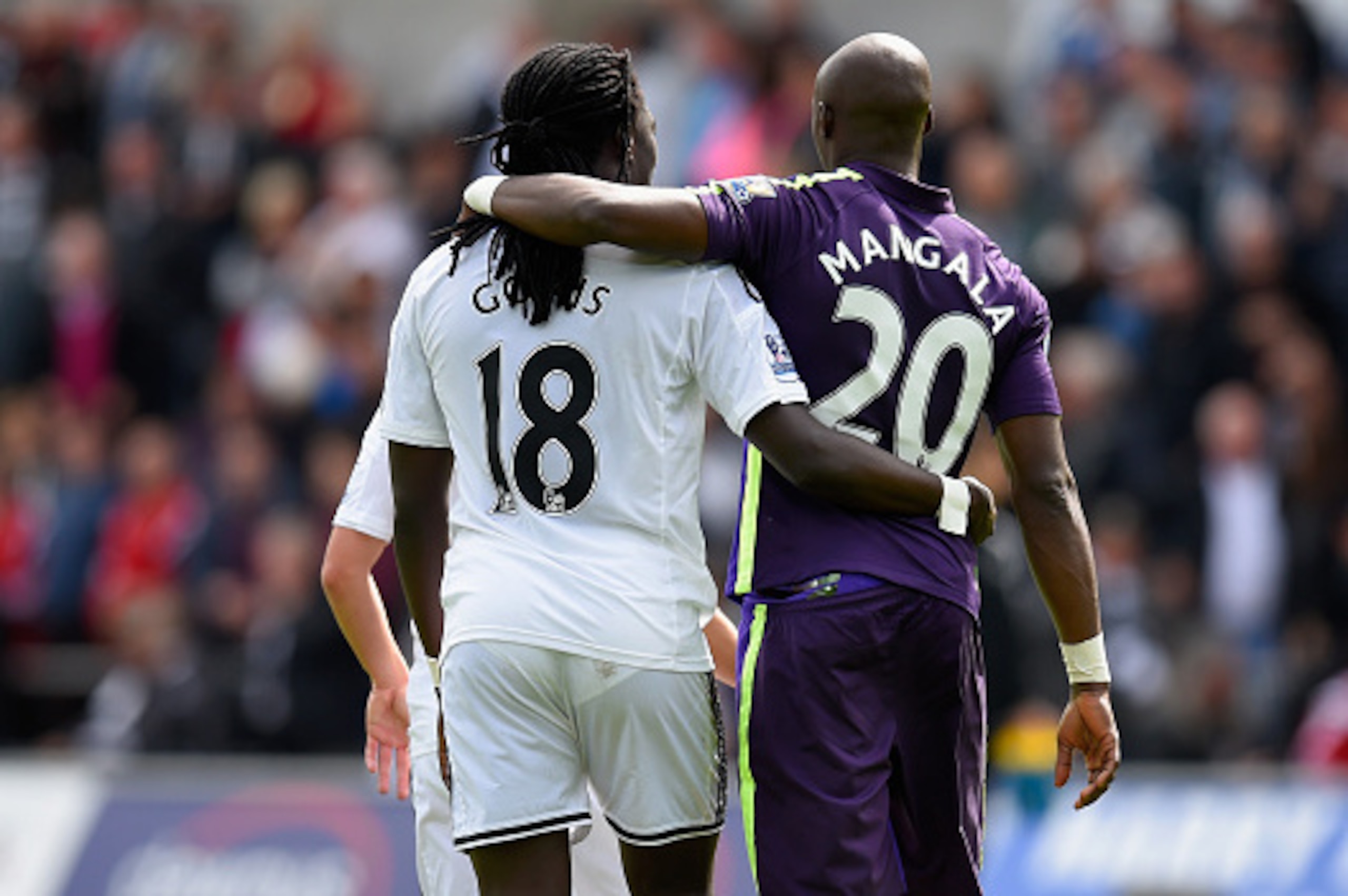 SWANSEA, WALES - MAY 17:  Swansea player Bafetimbi Gomis (l) and Eliaquim Mangala of City embrace after the Barclays Premier League match between Swansea City and Manchester City at Liberty Stadium on May 17, 2015 in Swansea, Wales.  (Photo by Stu Forster