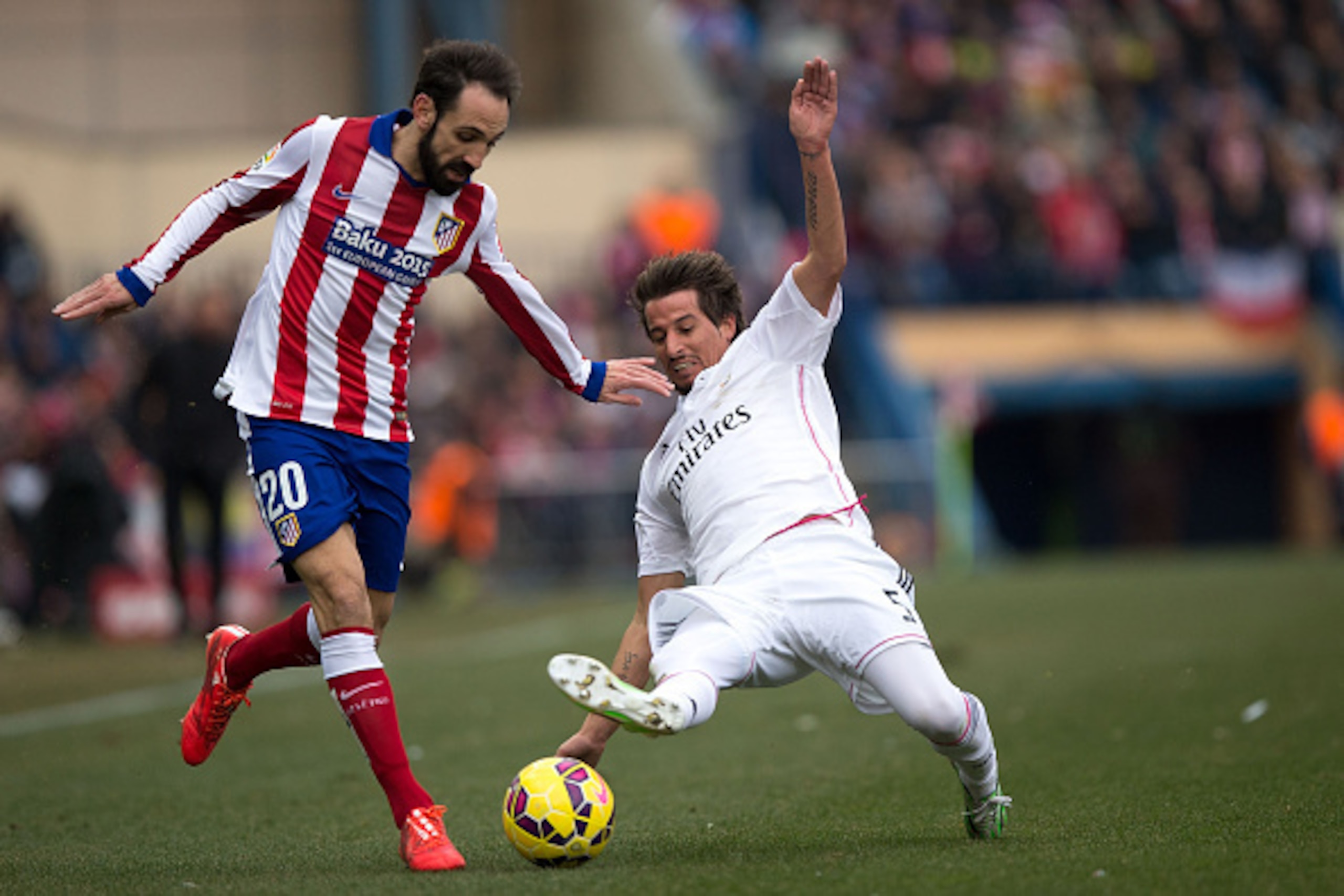 MADRID, SPAIN - FEBRUARY 07: Juan Francisco Torres alias Juanfran (L) of Atletico de Madrid competes for the ball with Fabio Coentrao (R) of Real Madrid CF during the La Liga match between Club Atletico de Madrid and Real Madrid CF at Vicente Calderon Sta