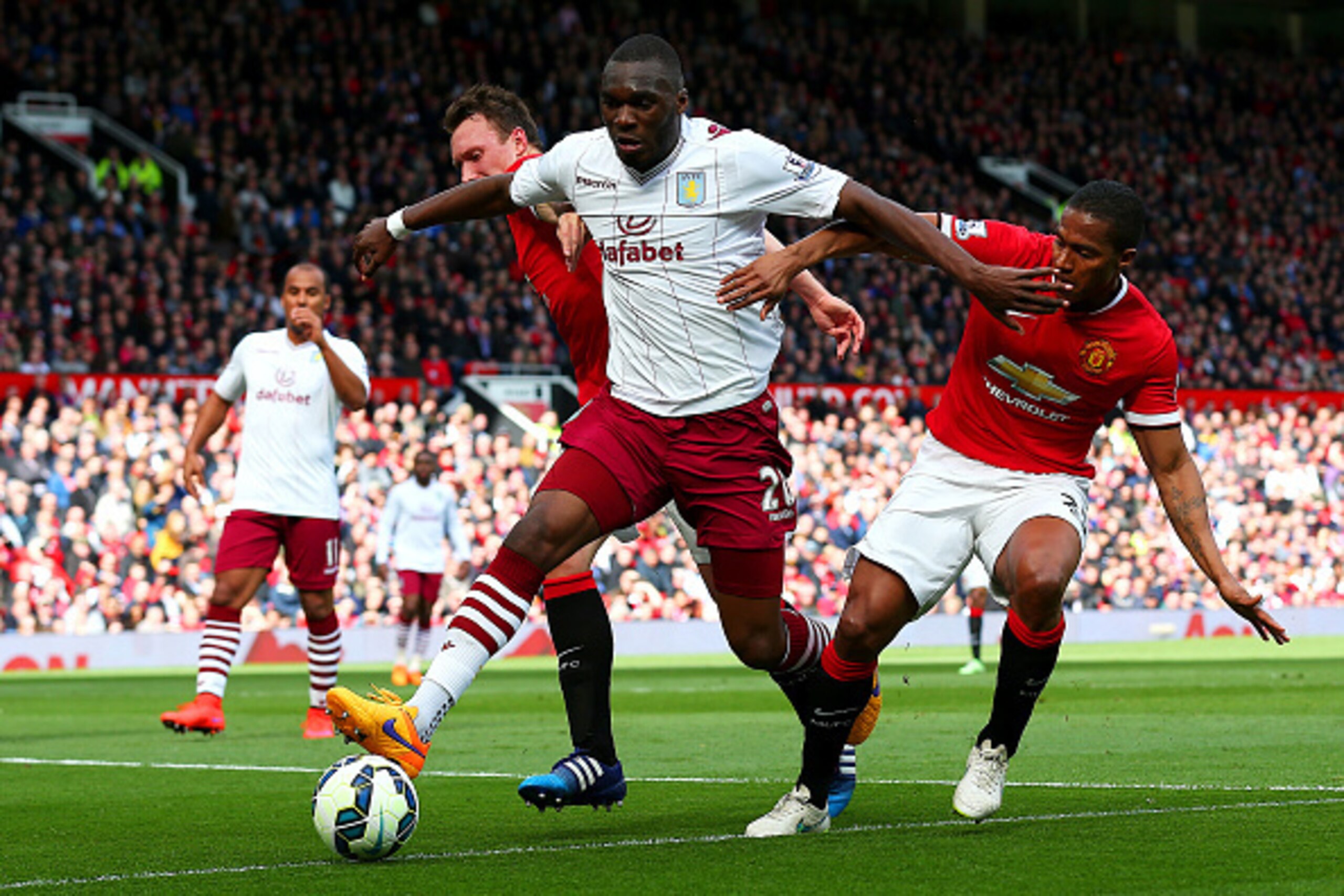 MANCHESTER, ENGLAND - APRIL 04:  Christian Benteke of Aston Villa battles for the ball with Luis Antonio Valencia and Phil Jones of Manchester United during the Barclays Premier League match between Manchester United and Aston Villa at Old Trafford on Apr