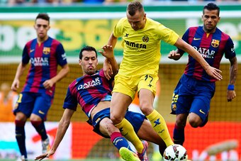 VILLARREAL, SPAIN - AUGUST 31:  Denis Cheryshev of Villarreal is tackled by Sergio Busquets of Barcelona during the La Liga match between Villarreal CF and FC Barcelona at El Madrigal stadium on August 31, 2014 in Villarreal, Spain.  (Photo by Manuel Quei