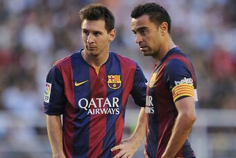 MADRID, SPAIN - OCTOBER 04:  Xavi Hernandez (R) and Lionel Messi line-up a free kick during the La Liga match between Rayo Vallecano de Madrid and FC Barcelona at Estadio Teresa Rivero on October 4, 2014 in Madrid, Spain.  (Photo by Denis Doyle/Getty Imag