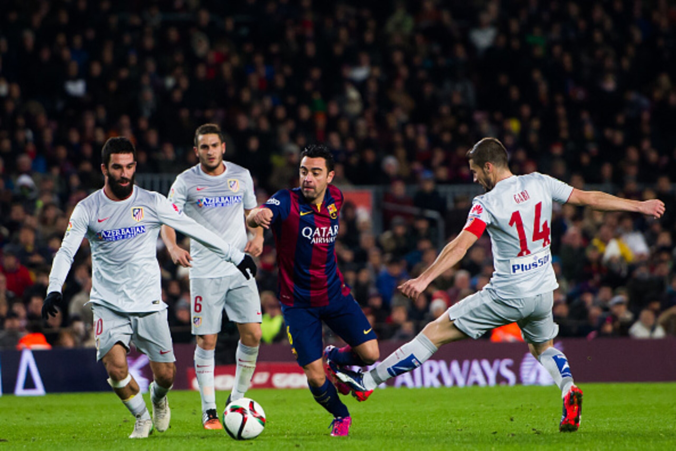 BARCELONA, SPAIN - JANUARY 21: Xavi Hernandez (C) of FC Barcelona conducts the ball between Arda Turan (L), Jorge Resurreccion 'Koke' (2nd L) and Gabriel 'Gabi' Fernandez (R) of Club Atletico de Madrid during the Copa del Rey Quarter-Final First Leg matc BARCELONA, SPAIN - JANUARY 21: Xavi Hernandez (C) of FC Barcelona conducts the ball between Arda Turan (L), Jorge Resurreccion 'Koke' (2nd L) and Gabriel 'Gabi' Fernandez (R) of Club Atletico de Madrid during the Copa del Rey Quarter-Final First Leg matc