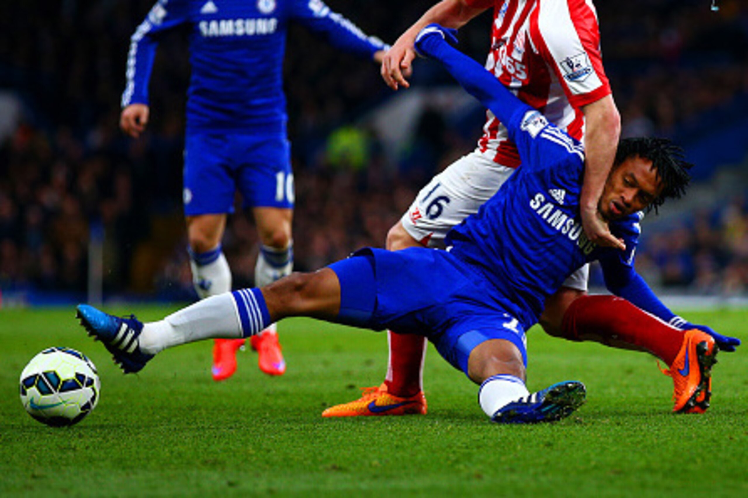 LONDON, ENGLAND - APRIL 04:  Juan Cuadrado of Chelsea battles for the ball with Charlie Adam of Stoke City during the Barclays Premier League match between Chelsea and Stoke City at Stamford Bridge on April 4, 2015 in London, England.  (Photo by Ian Walto