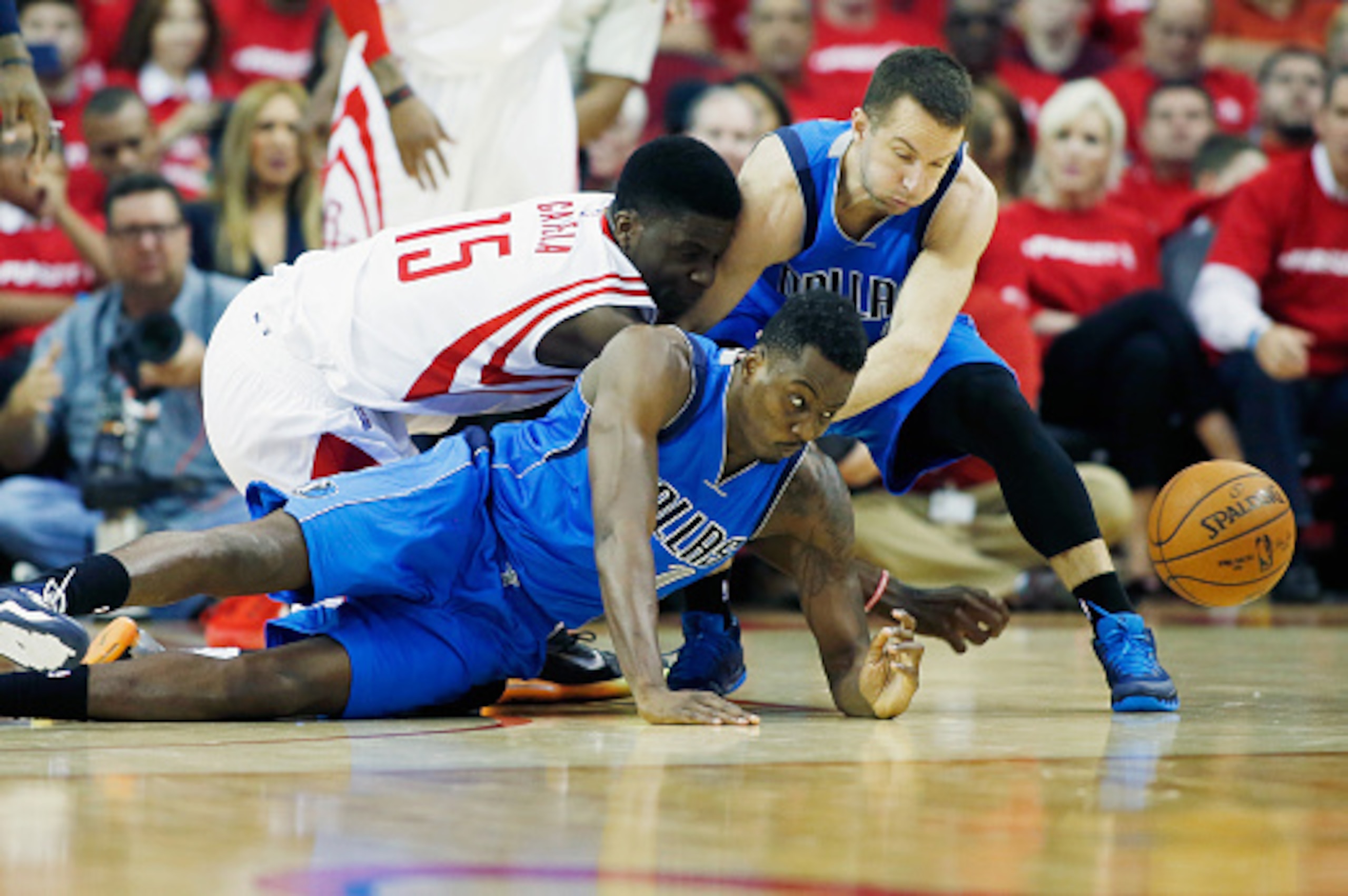 HOUSTON, TX - APRIL 18:  Clint Capela #15 of the Houston Rockets battles for a loose ball with Al-Farouq Aminu #7 and J.J. Barea #5 of the Dallas Mavericks during Game One in the Western Conference Quarterfinals of the 2015 NBA Playoffs on April 18, 2015 