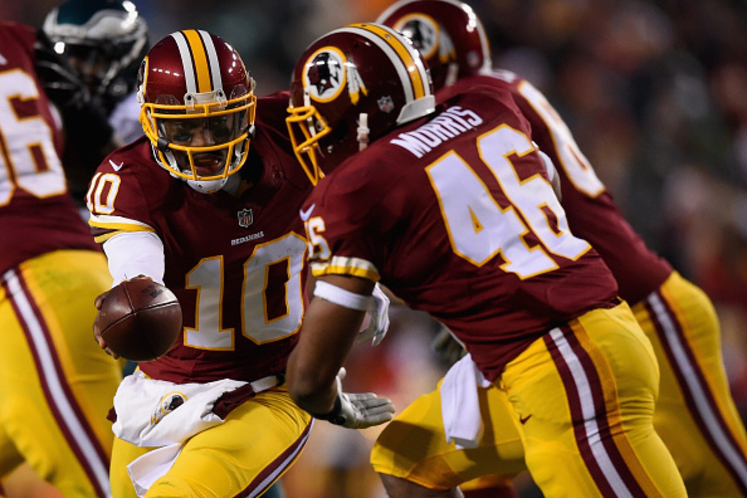 LANDOVER, MD - DECEMBER 20: Quarterback Robert Griffin III #10 of the Washington Redskins hands off to running back Alfred Morris #46 in the second quarter of a game against the Philadelphia Eagles at FedExField on December 20, 2014 in Landover, Maryland.
